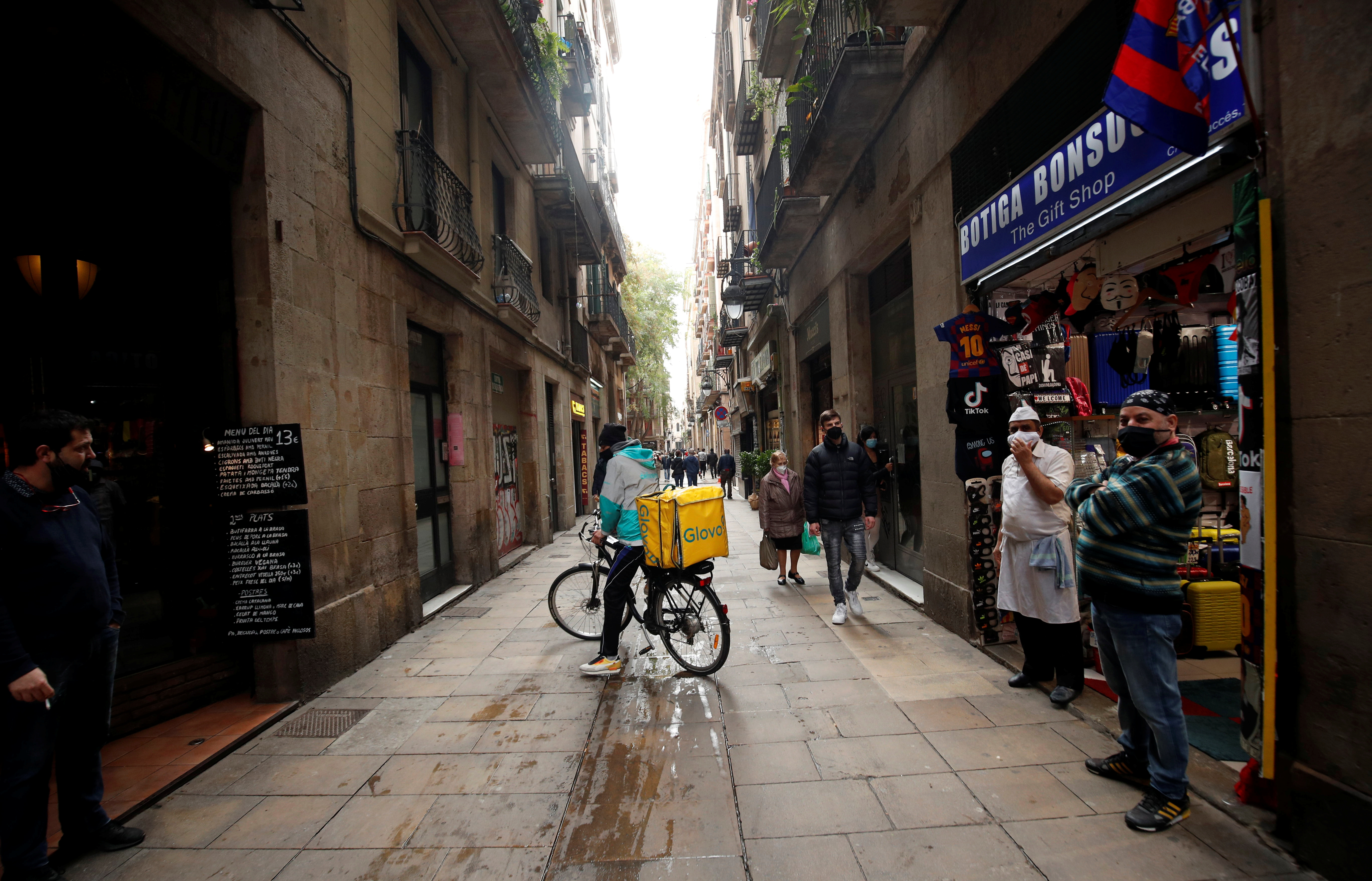 A delivery rider of Glovo stops in a street of Barcelona