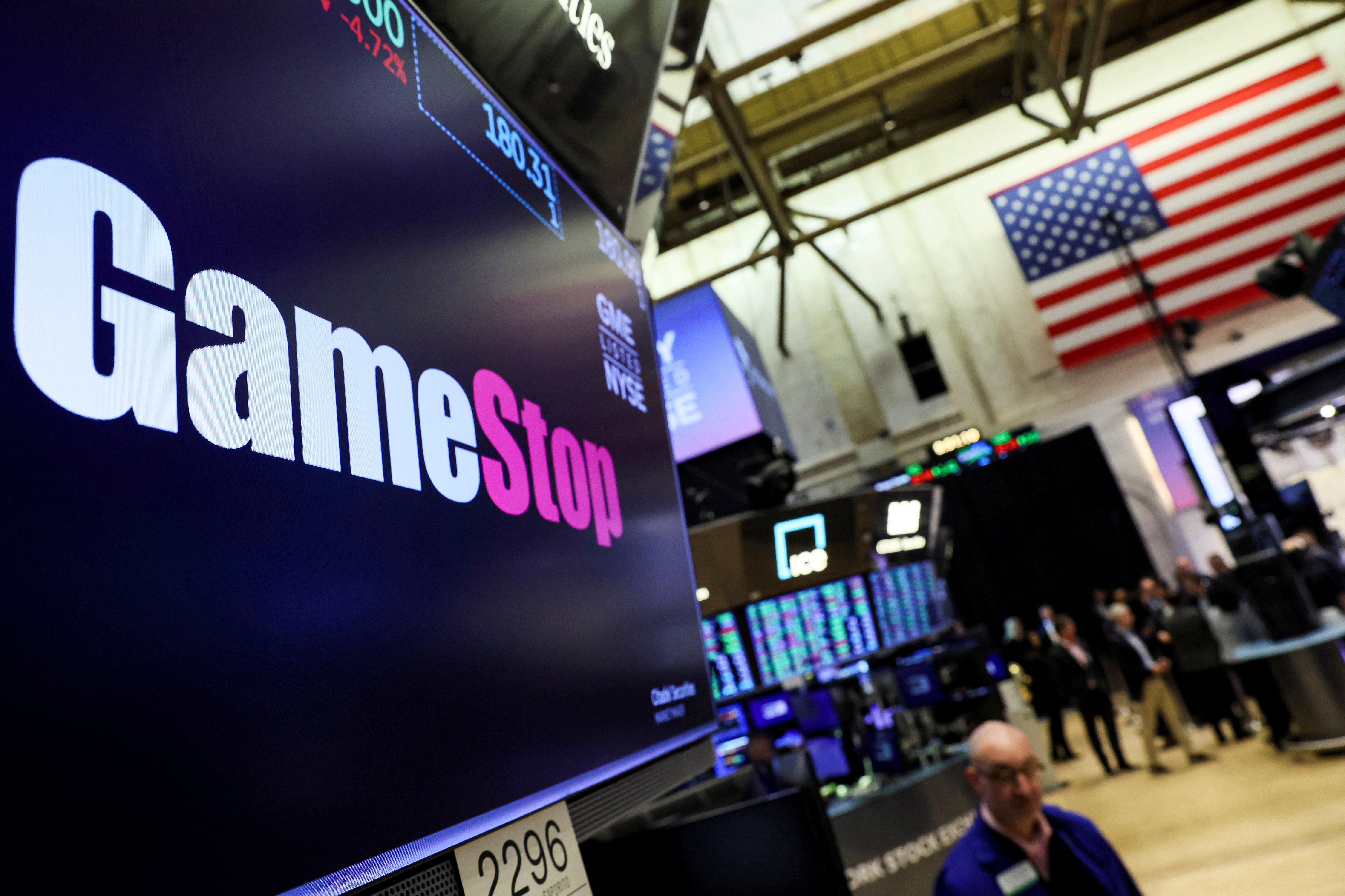 A screen displays the logo and trading information for GameStop at the NYSE  in New York