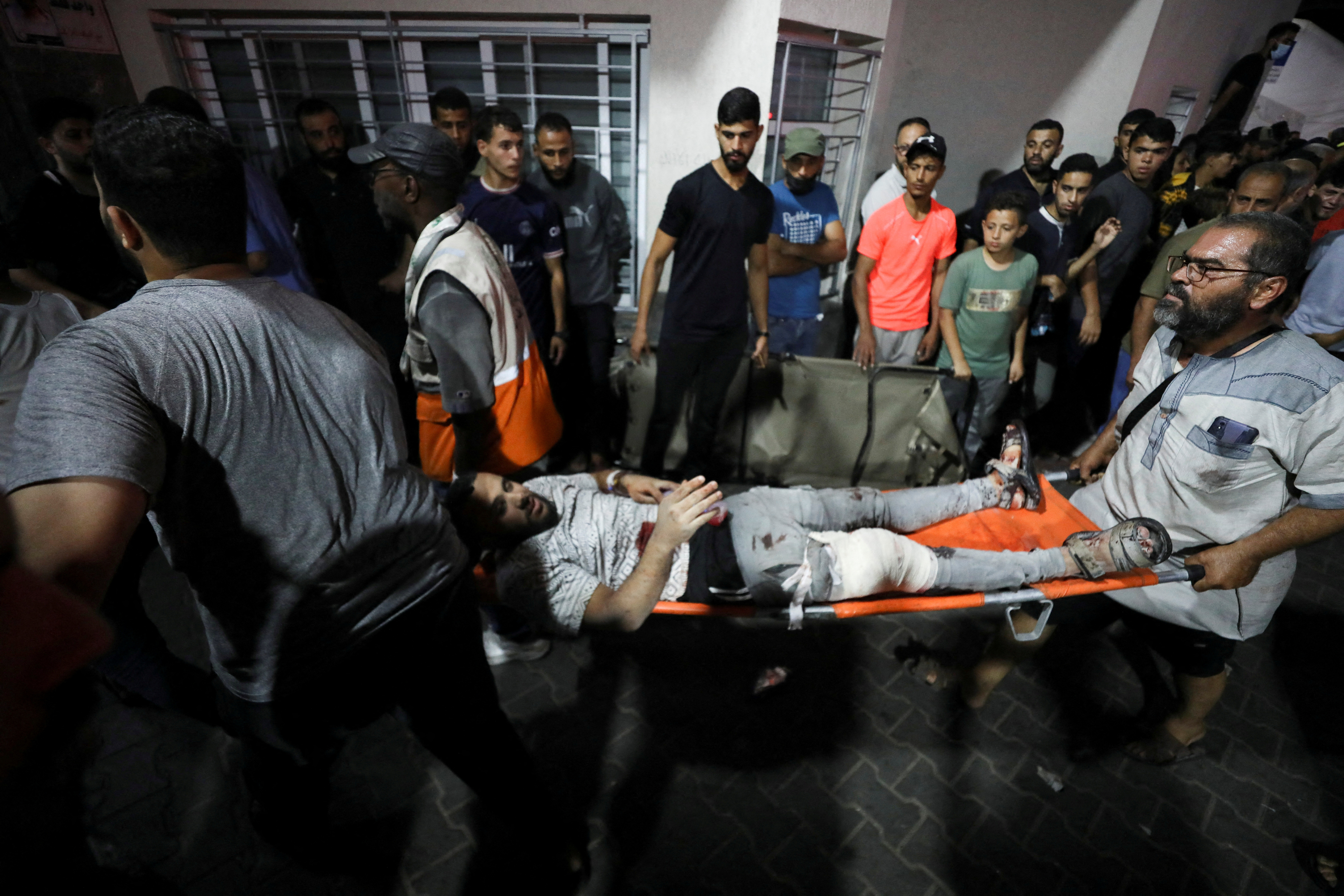 People are assisted at Shifa Hospital after hundreds of Palestinians were killed in a blast at Al-Ahli hospital in Gaza that Israeli and Palestinian officials blamed on each other