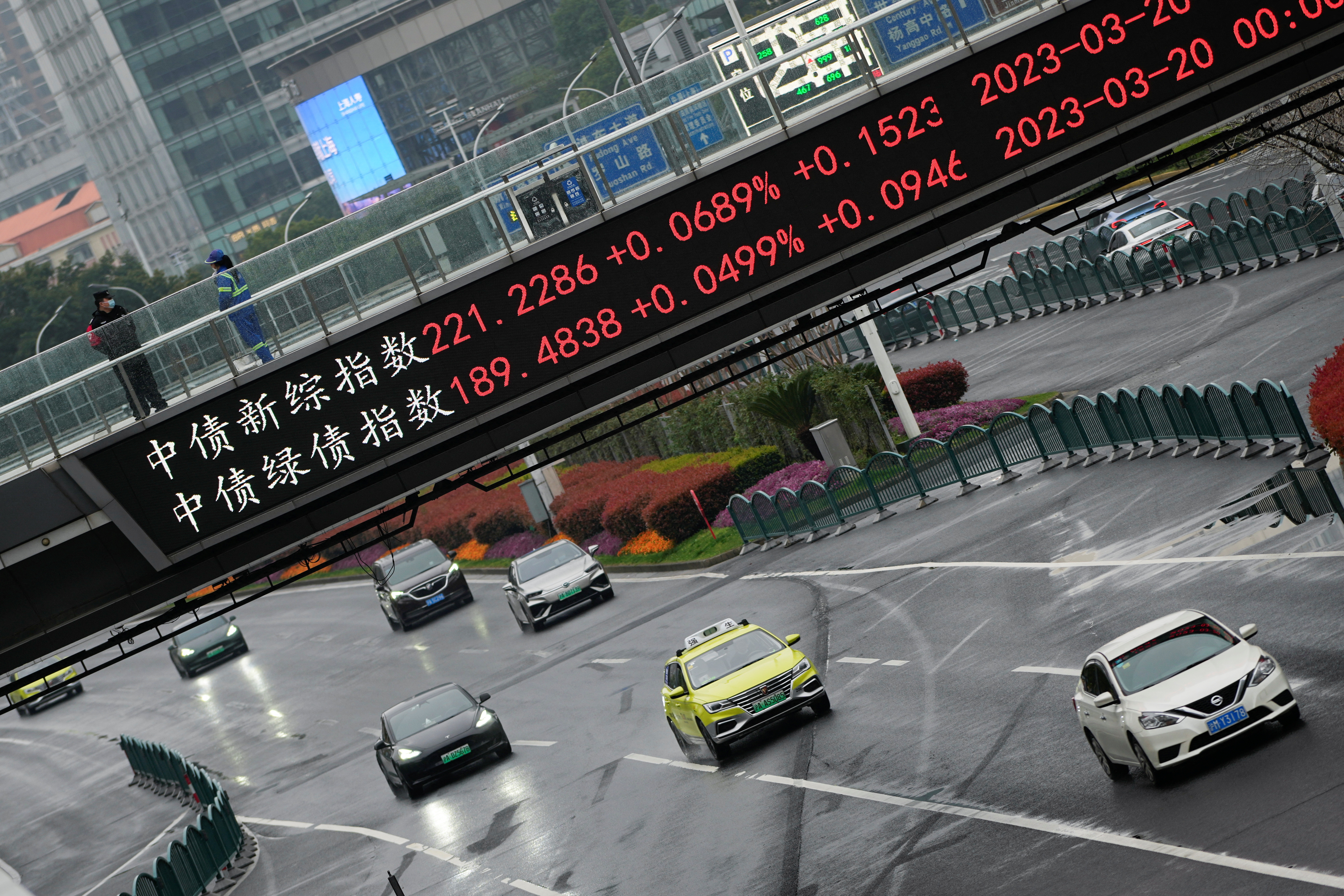 An electronic board shows stock indexes at the Lujiazui financial district in Shanghai