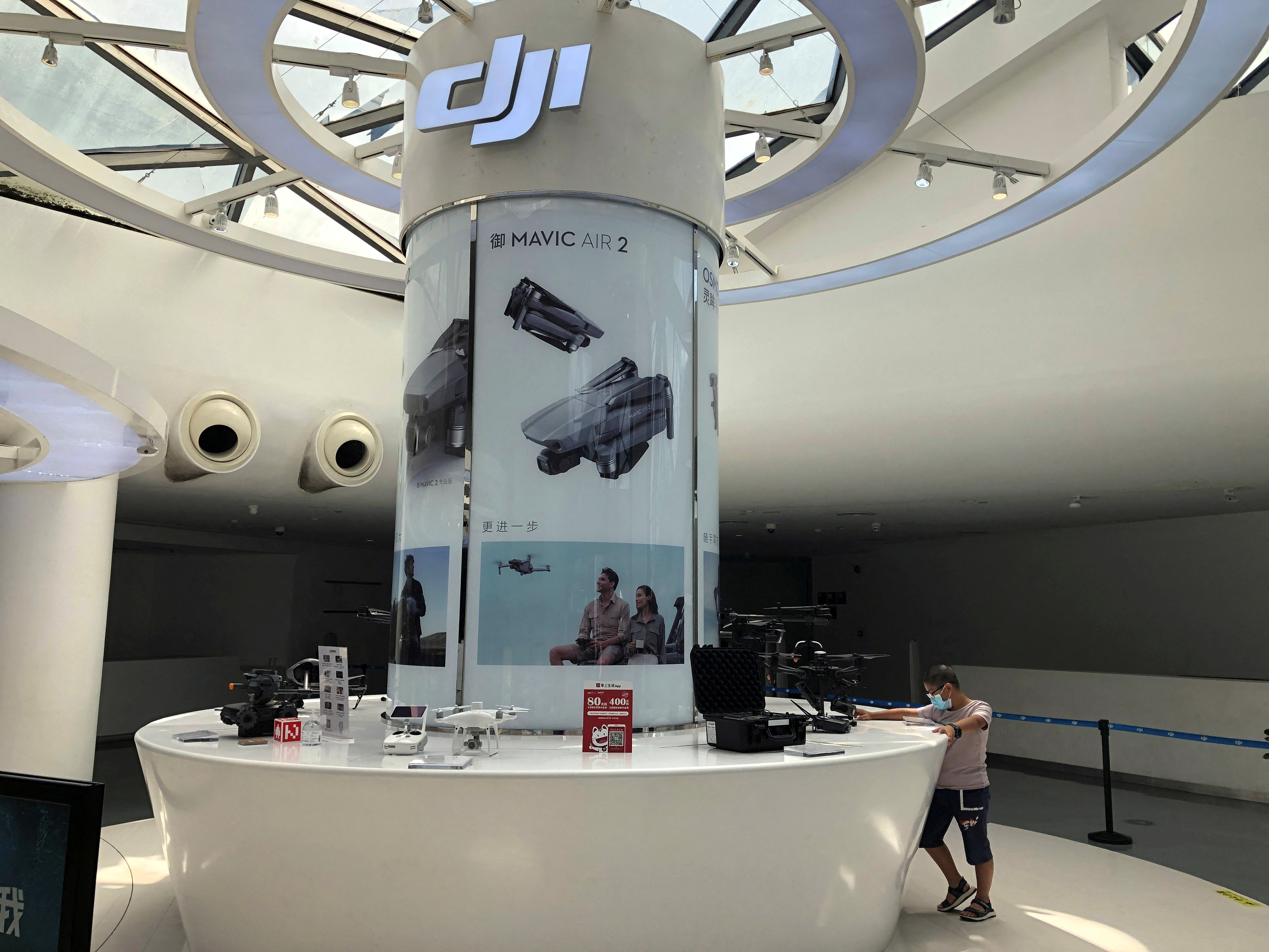 Man wearing a face mask following the coronavirus disease (COVID-19) outbreak is seen at a counter displaying drones and other products at DJI's flagship store in Shenzhen
