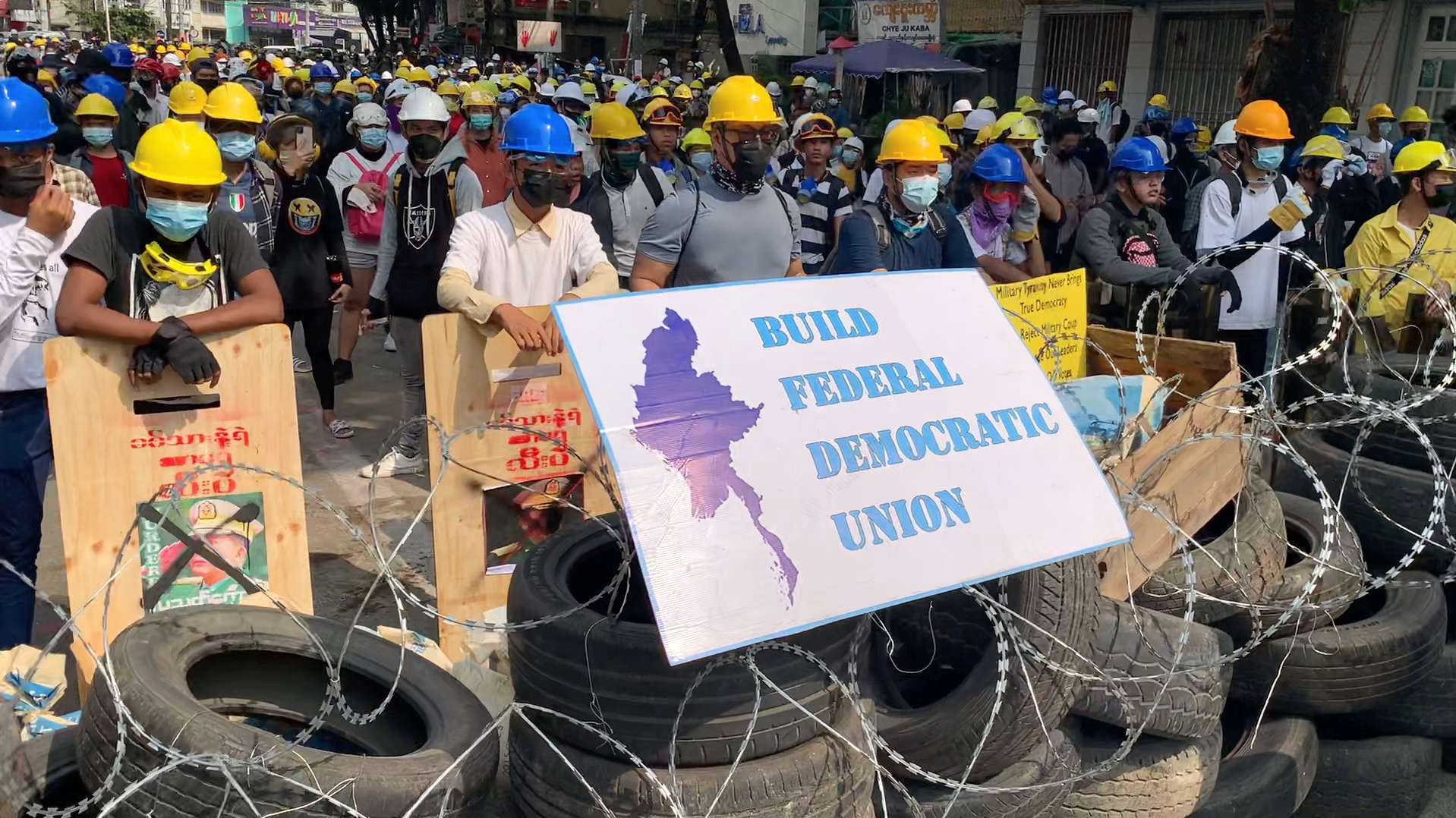Video grab of protesters standing behind a barricade in Sanchaung, Yangon, Myanmar
