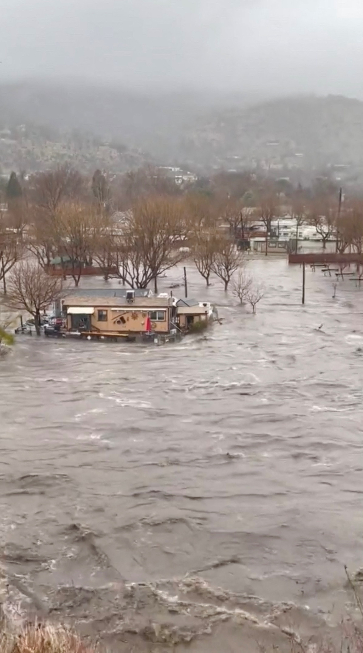 Raging floodwaters encircle homes in California