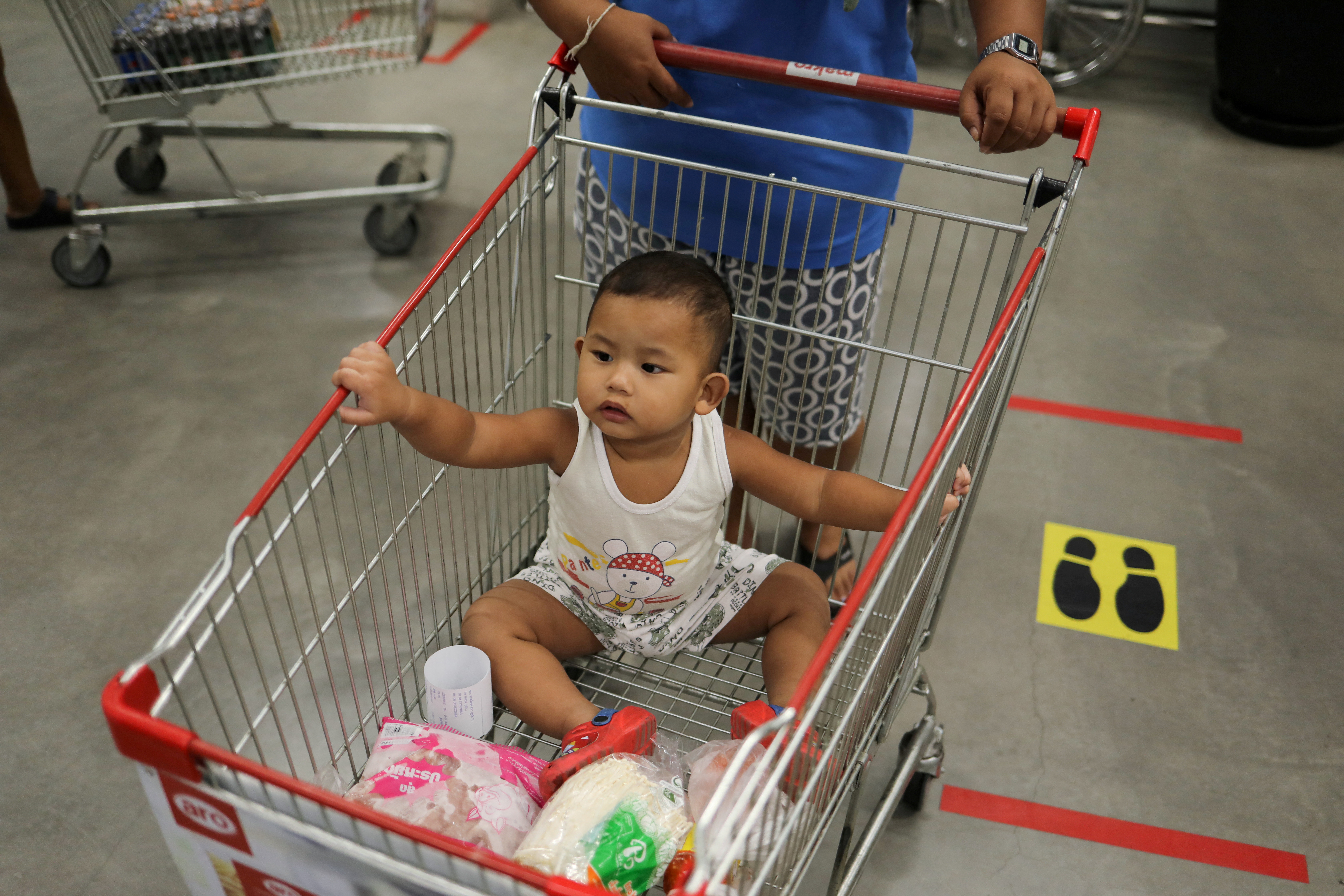 A baby is seen in a shopping cart after the government eased some protective measures following the coronavirus disease (COVID-19) outbreak, in Bangkok