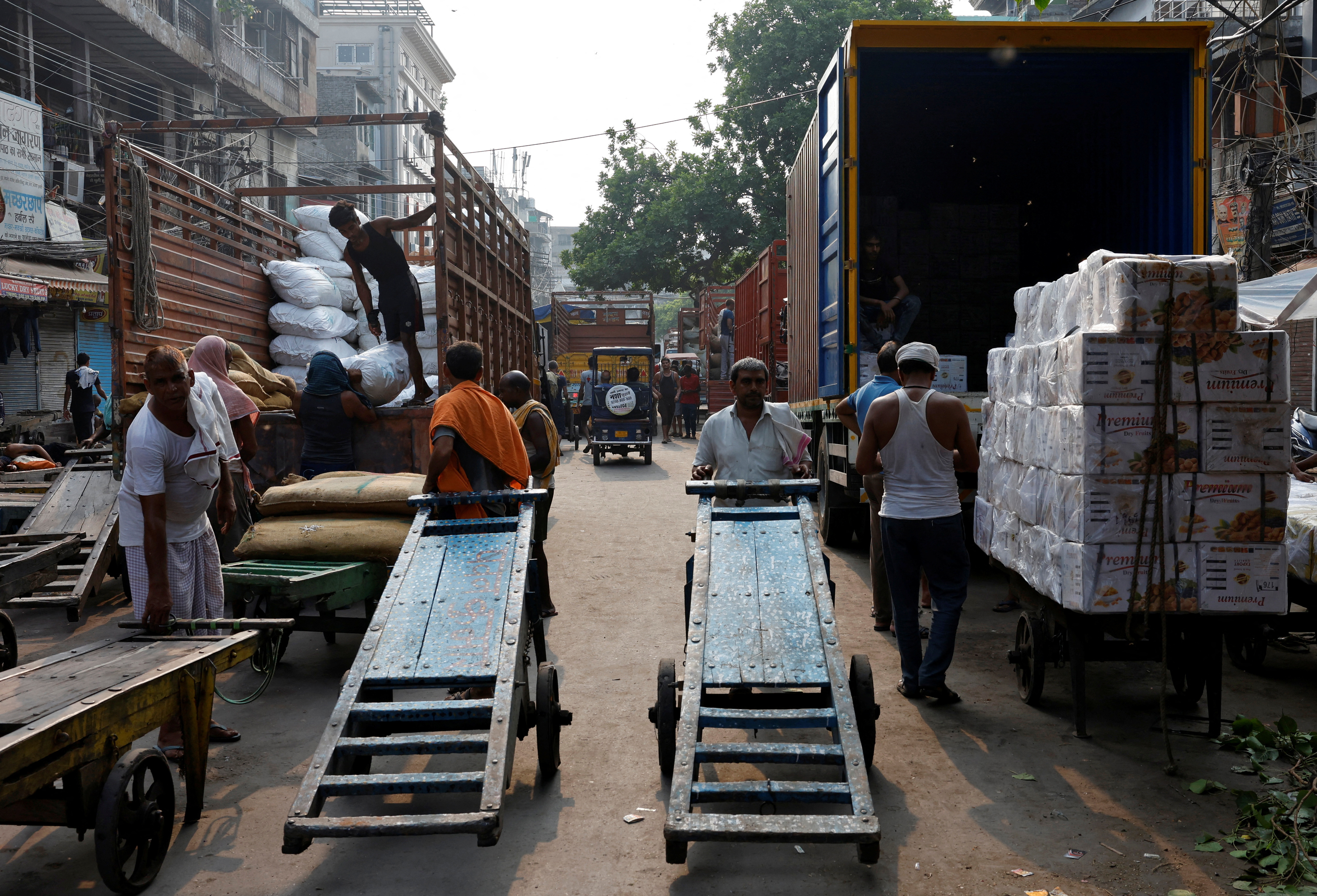 Labourers unload spices and dry fruits from supply trucks at a wholesale market in the old quarters of Delhi