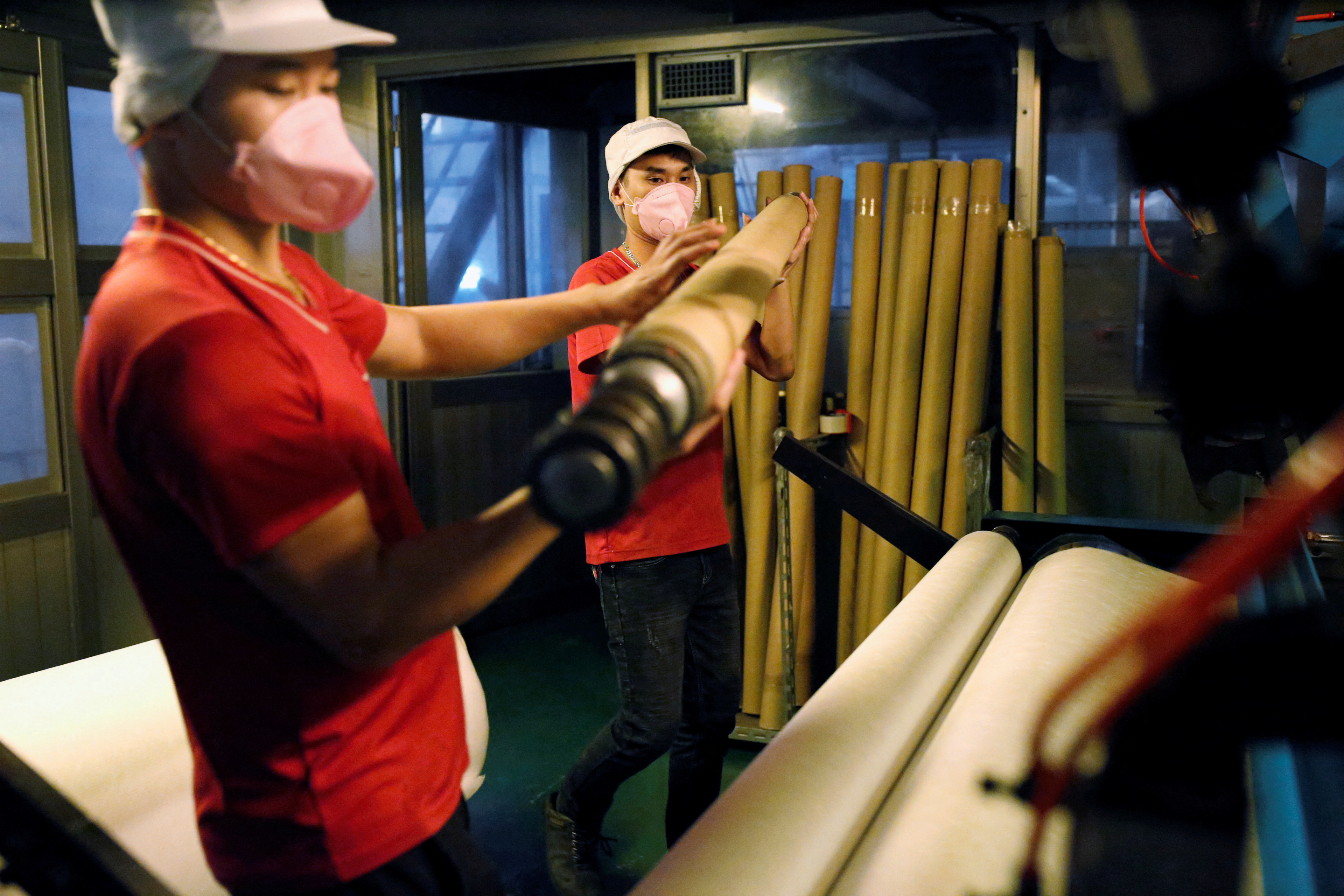 Staff work inside a non woven filter fabric factory, where the fabric is used to make surgical face masks, in Taoyuan,