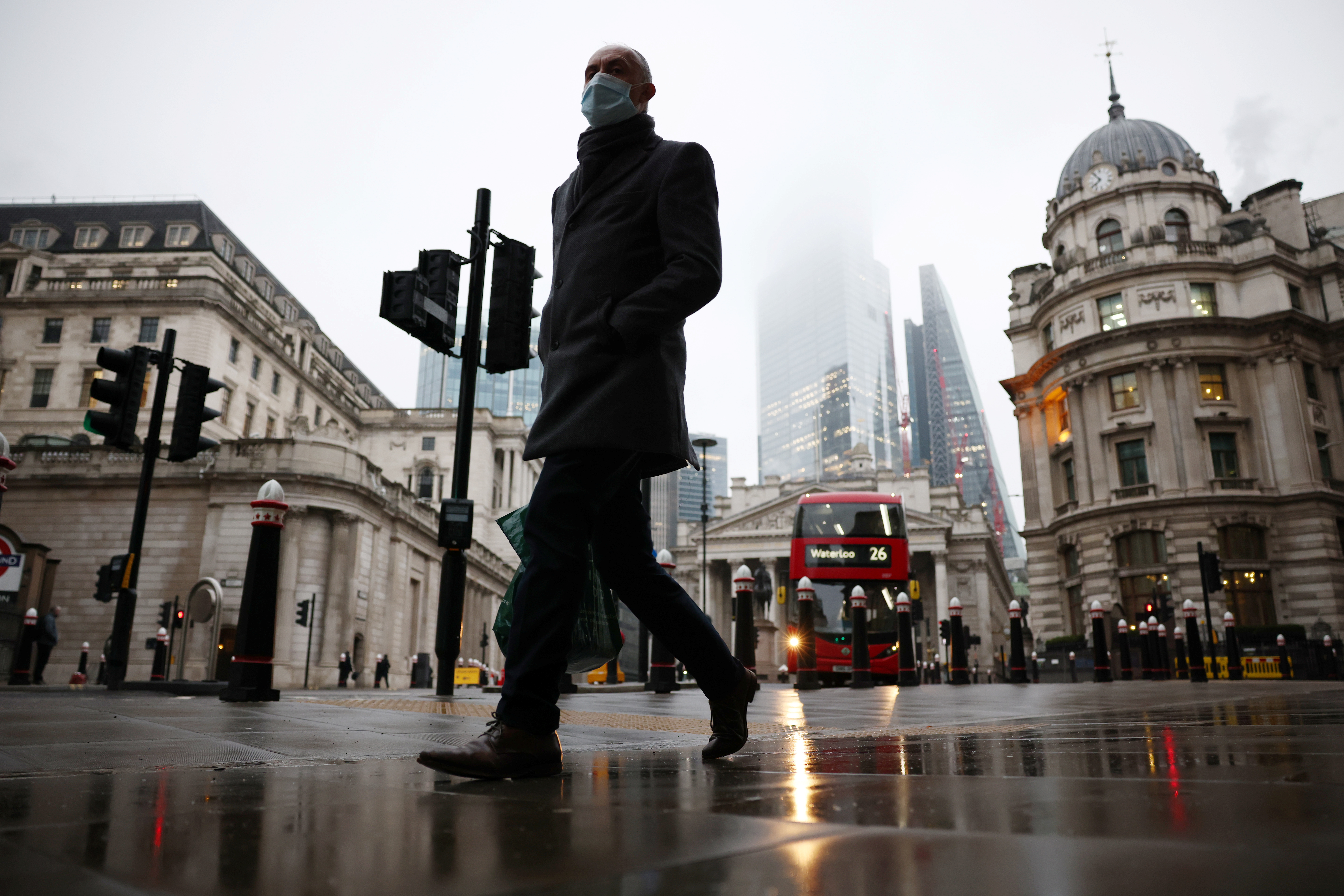 A man walks through the City of London financial district, amid the coronavirus disease (COVID-19) outbreak, in London, Britain, March 4, 2021.  REUTERS/Henry Nicholls