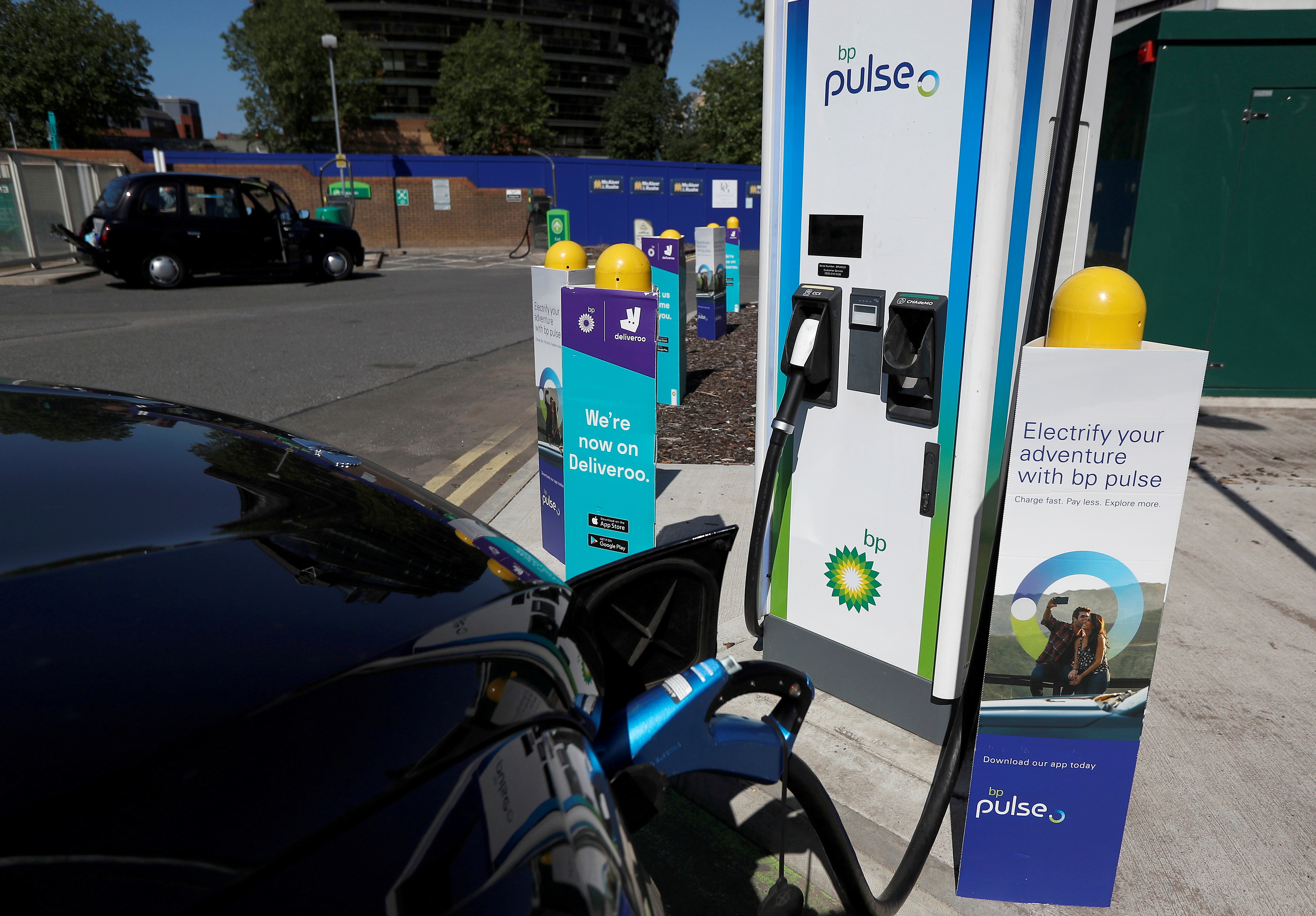 An electric powered taxi is seen being charged at a BP Pulse electric vehicle charging point in London