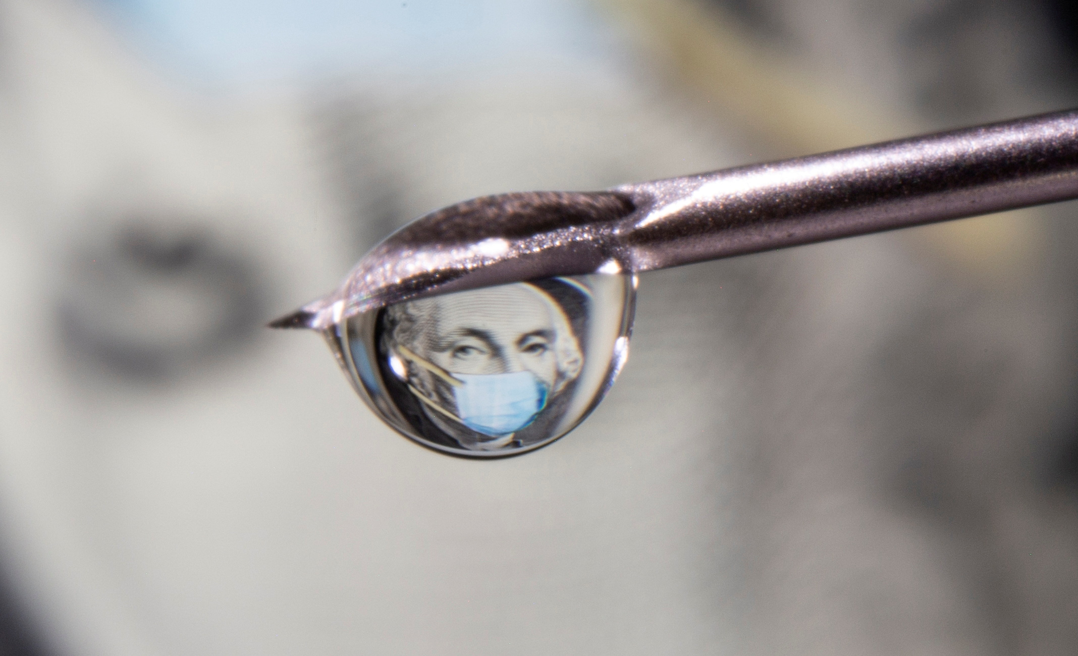 George Washington is seen with a printed medical mask on a one dollar bill reflected in a drop on a syringe needle in this illustration