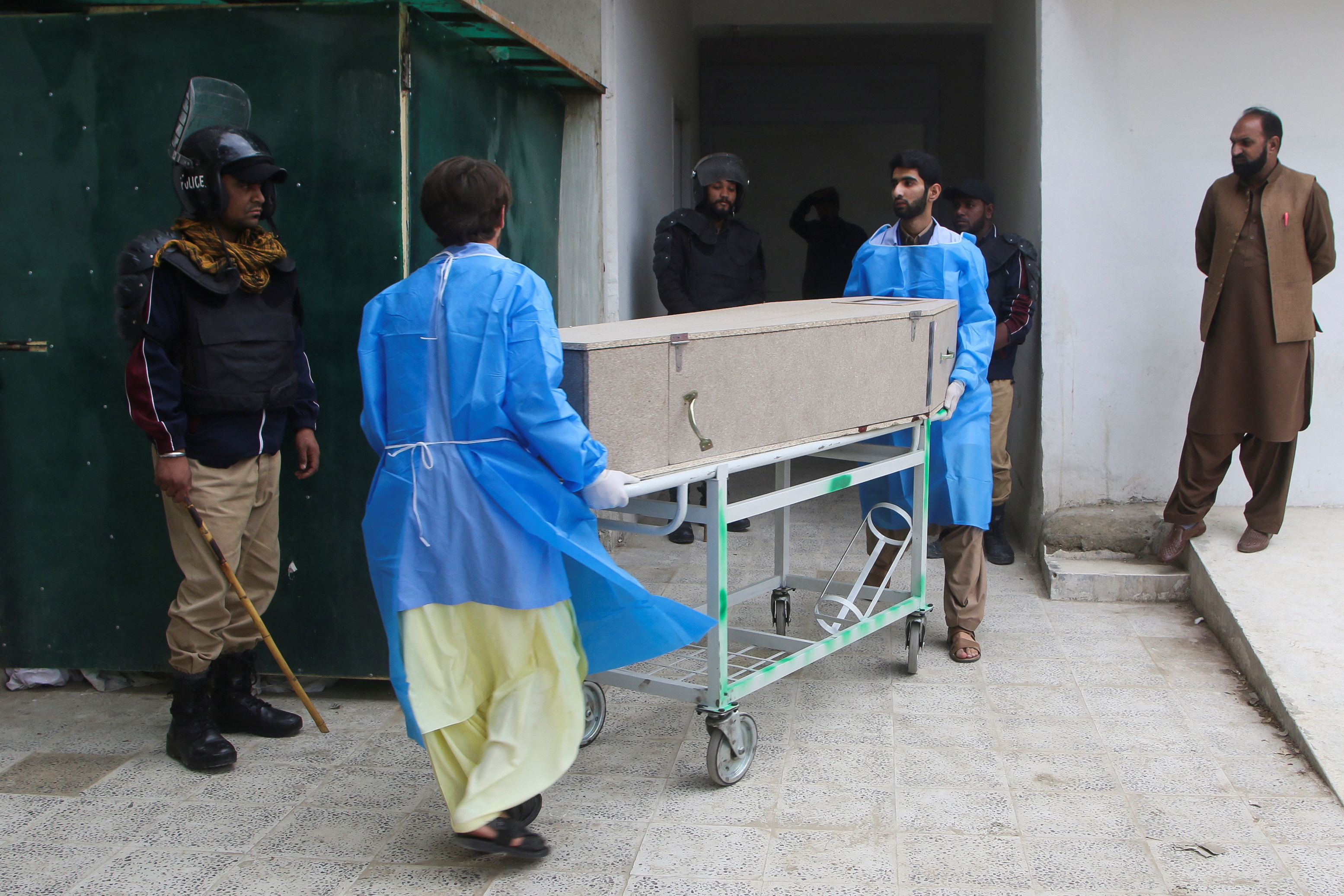 Paramedic staff move a coffin box, after gunmen shot and killed nine men after abducting them from a Iran-bound bus in Noshki district, at a hospital in Quetta