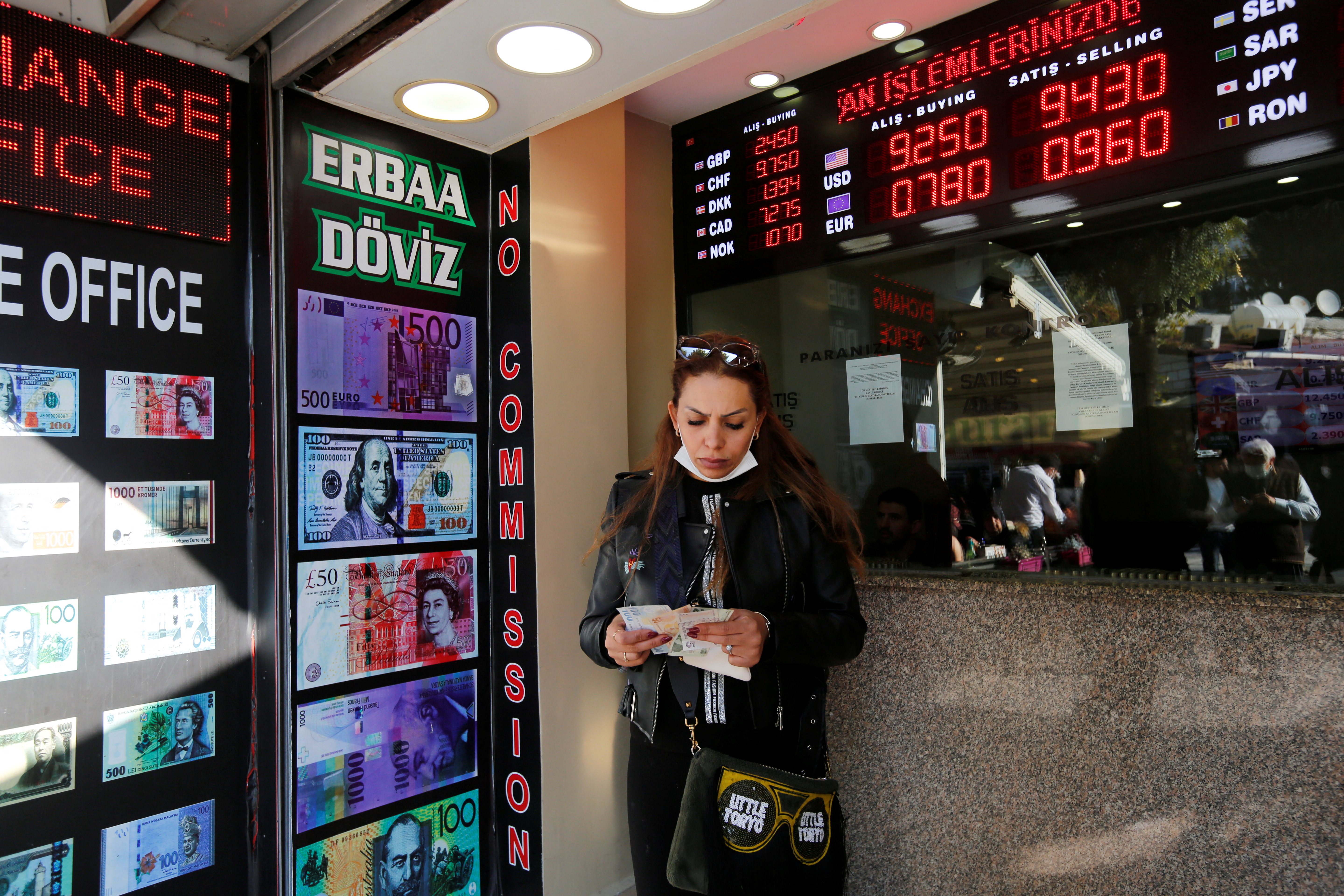 A woman counts her money at an exchange office in Istanbul
