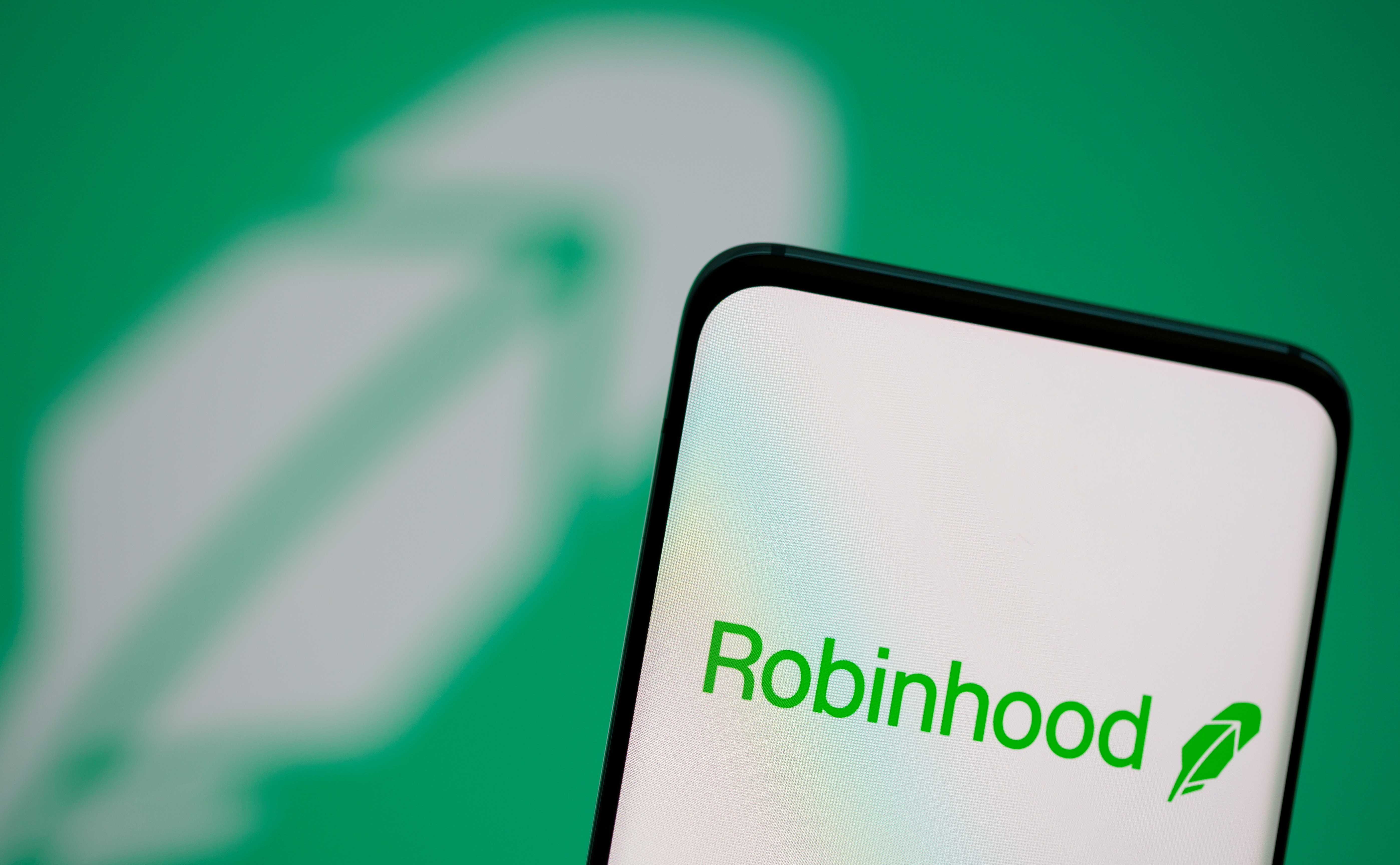 Robinhood logo is seen on a smartphone in front of a displayed same logo in this illustration taken, July 2, 2021. REUTERS/Dado Ruvic/Illustration/File Photo