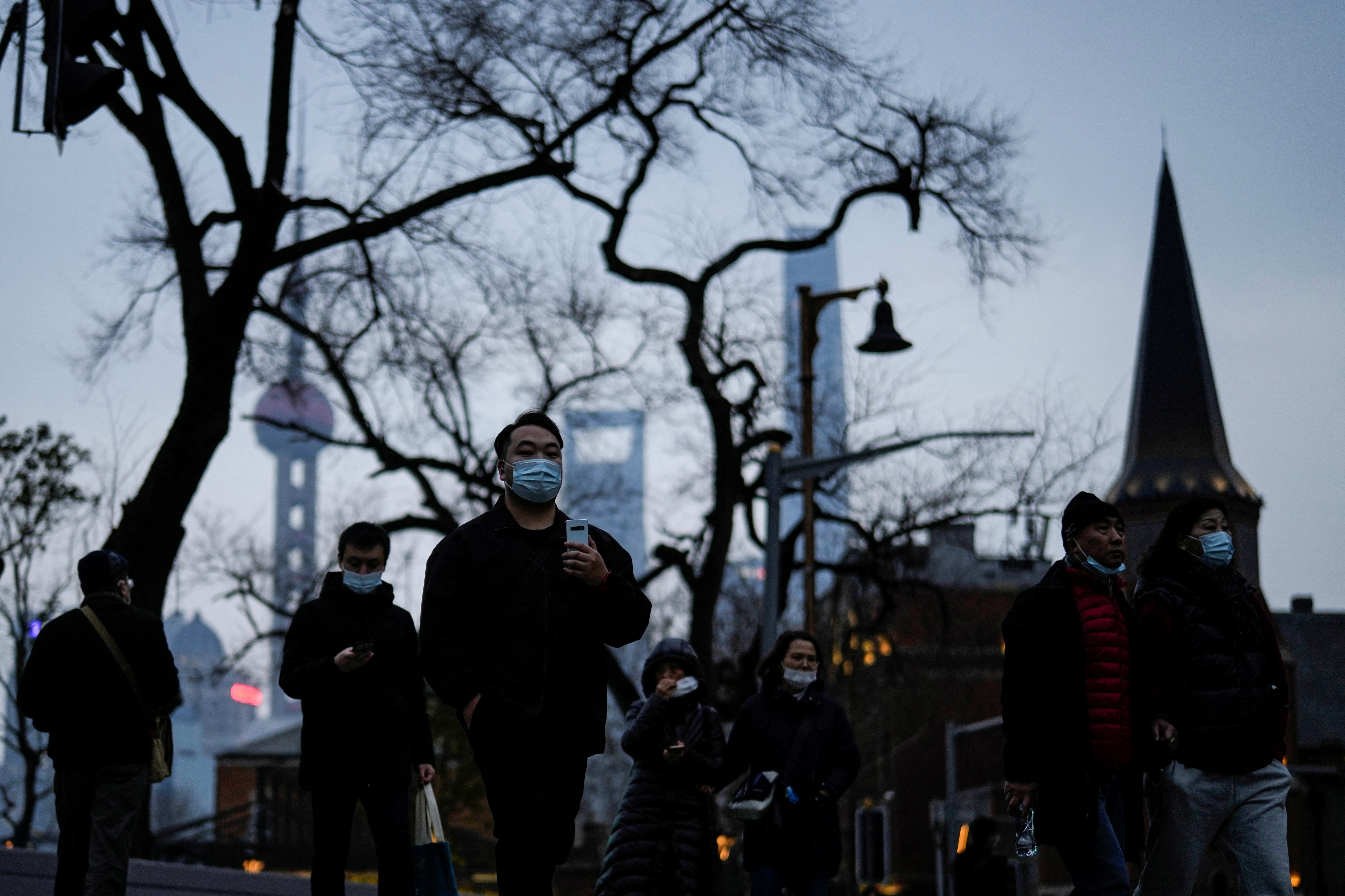 People wearing protective masks walk on street, following new coronavirus disease (COVID-19) cases in Shanghai