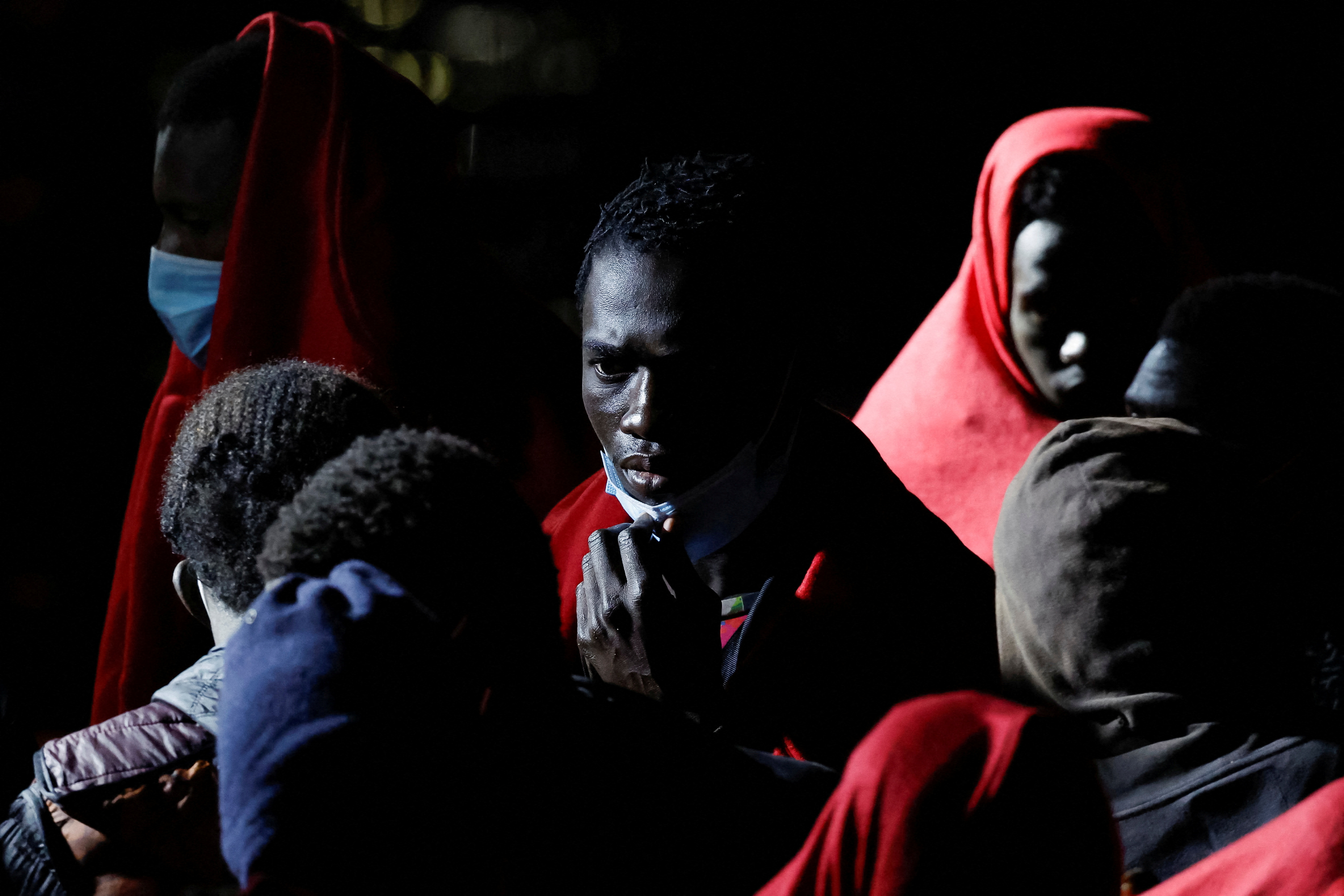 Migrants wait to disembark from a Spanish coast guard vessel, in the port of Arguineguin