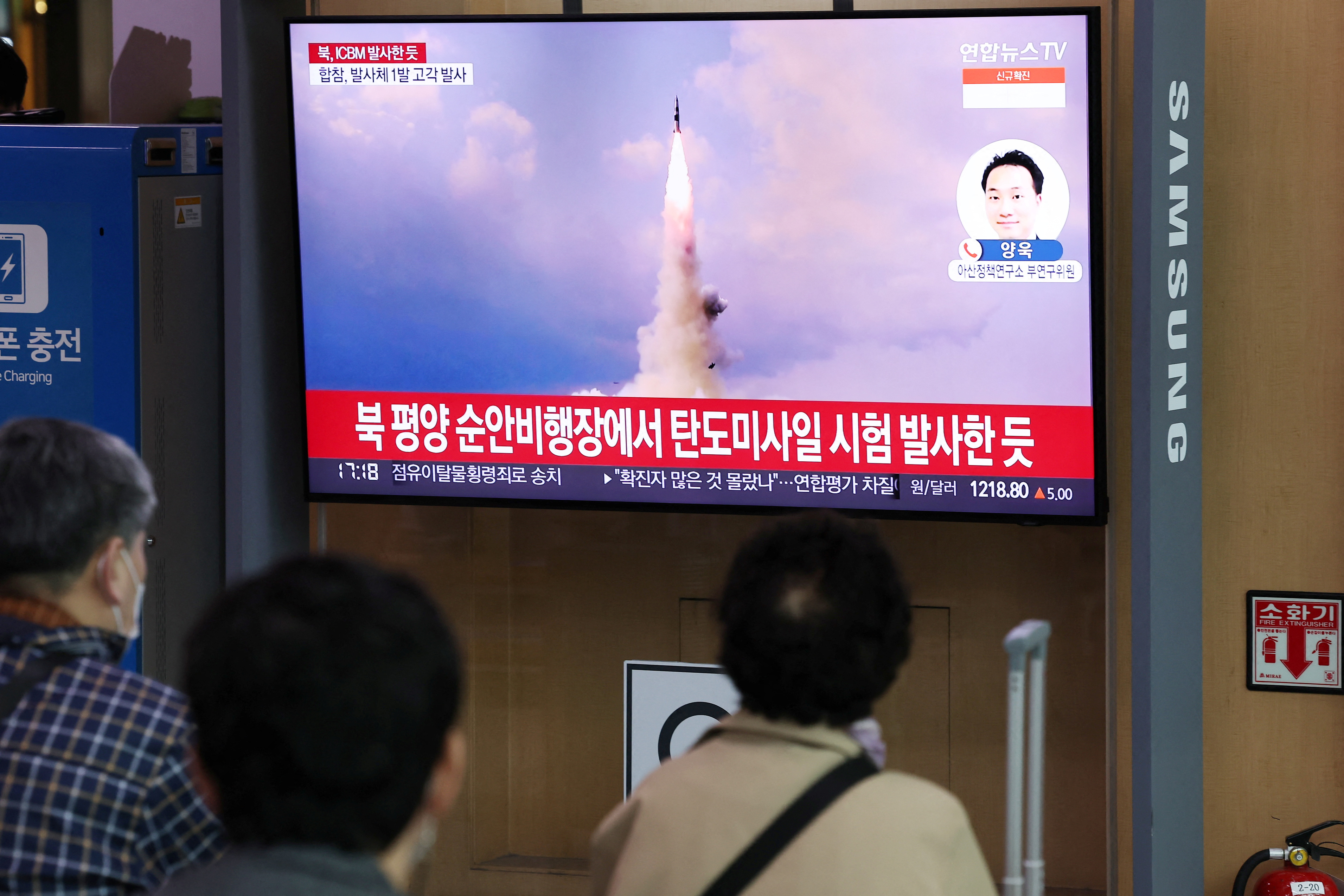 People watch a TV broadcasting a news report on North Korea's intercontinental ballistic missile (ICBM) test, in Seoul