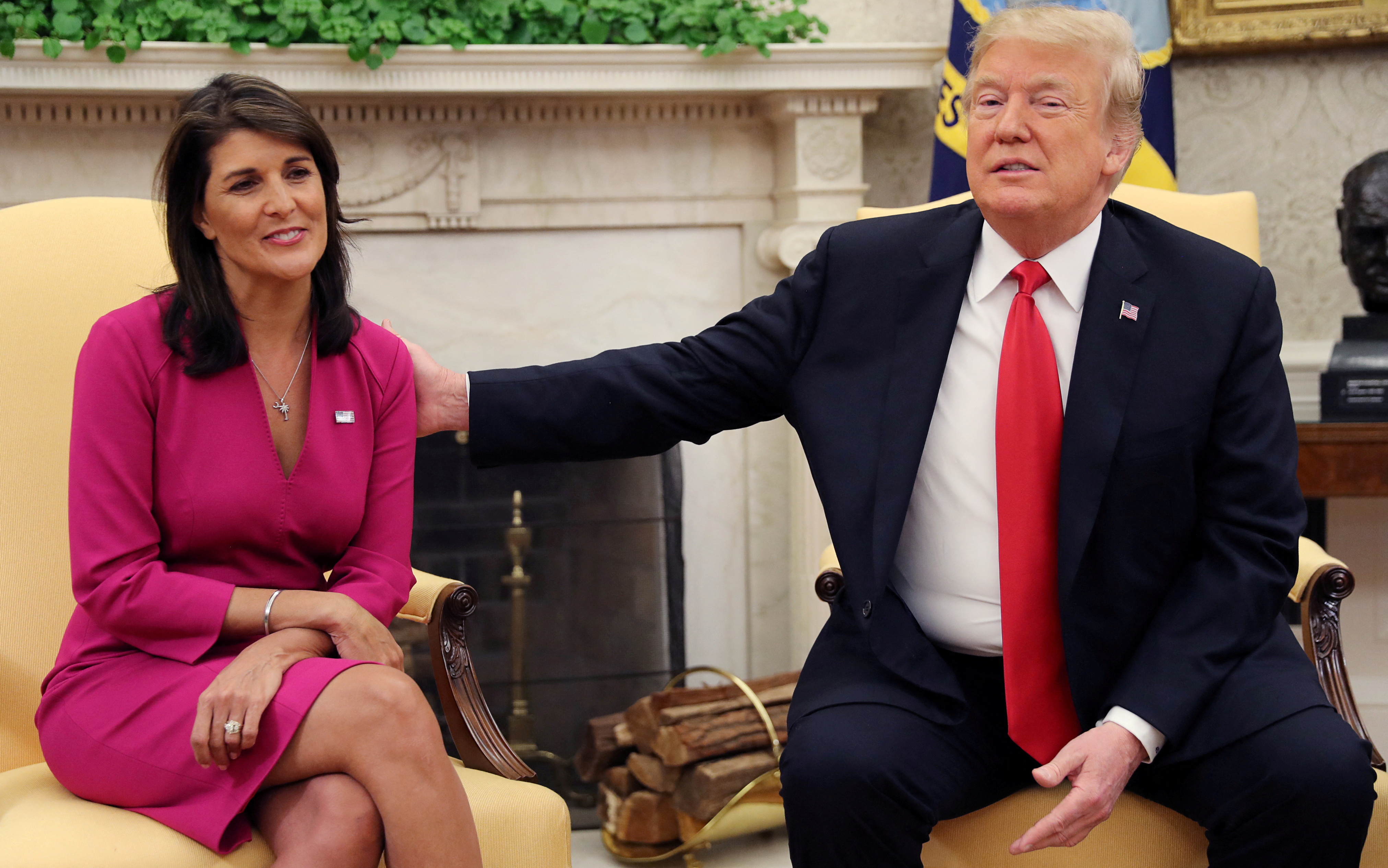 U.S. President Trump reaches out to uutgoing U.S. Ambassador to the U.N. Haley as they meet in the Oval Office of the White House in Washington