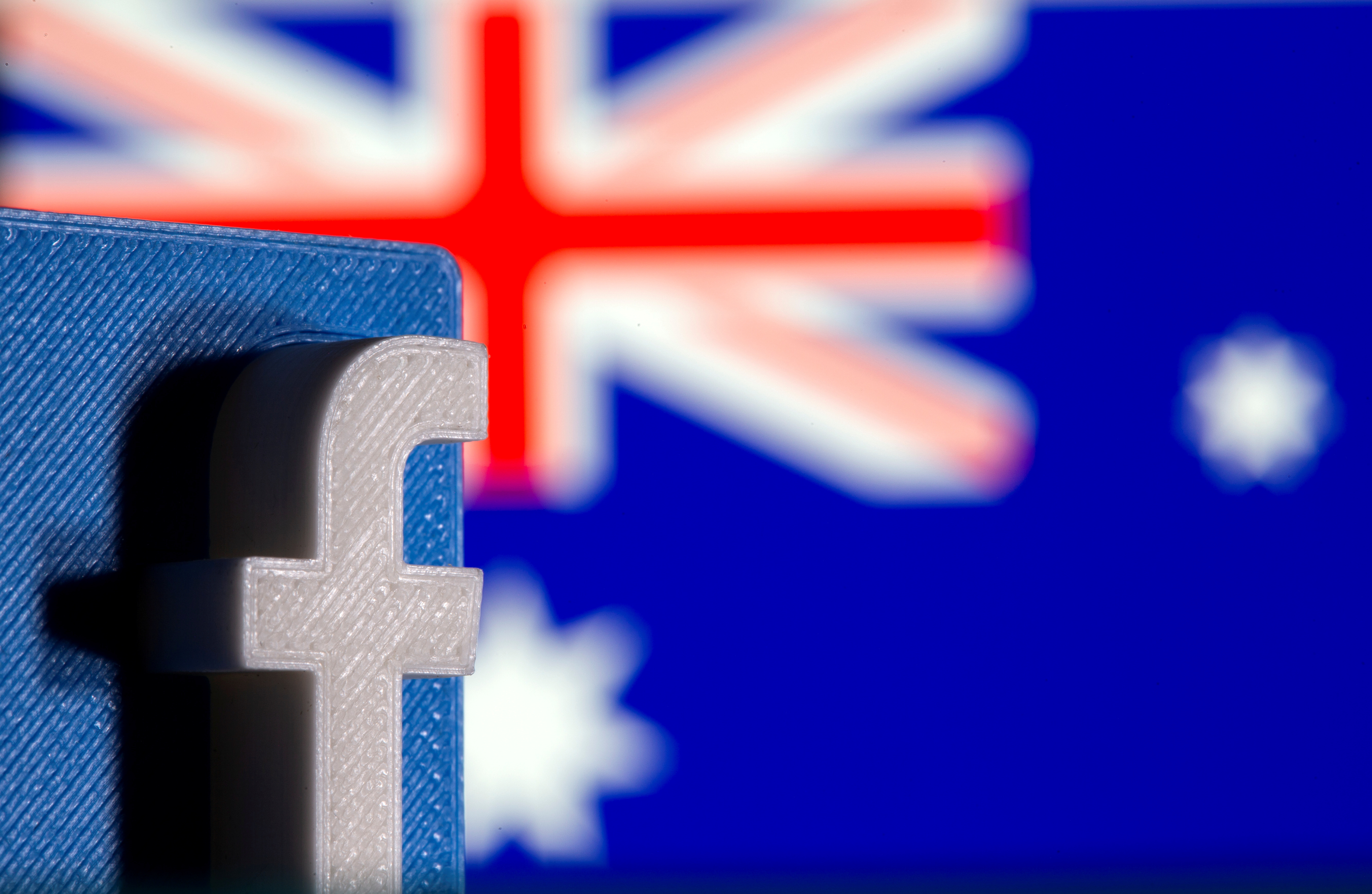 A 3D printed Facebook logo is seen in front of displayed Australia's flag in this illustration photo