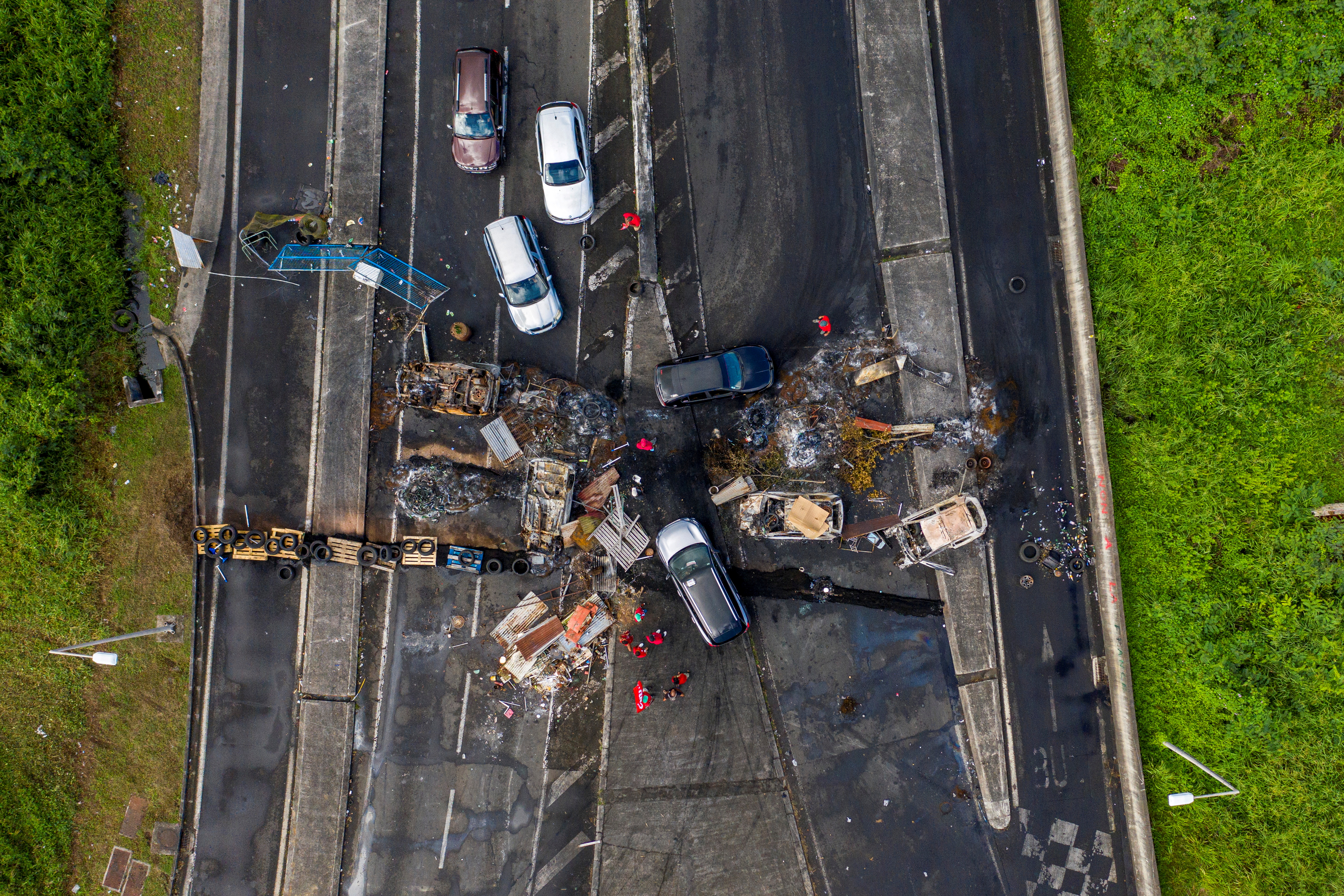 An aerial view of burnt cars and debris blocking a road in the neighborhood of Lamentin after unrest triggered by COVID-19 curbs, which have have already rocked the nearby island of Guadeloupe, in Fort-De-France, Martinique November 27, 2021. Picture taken with a drone. REUTERS/Ricardo Arduengo 