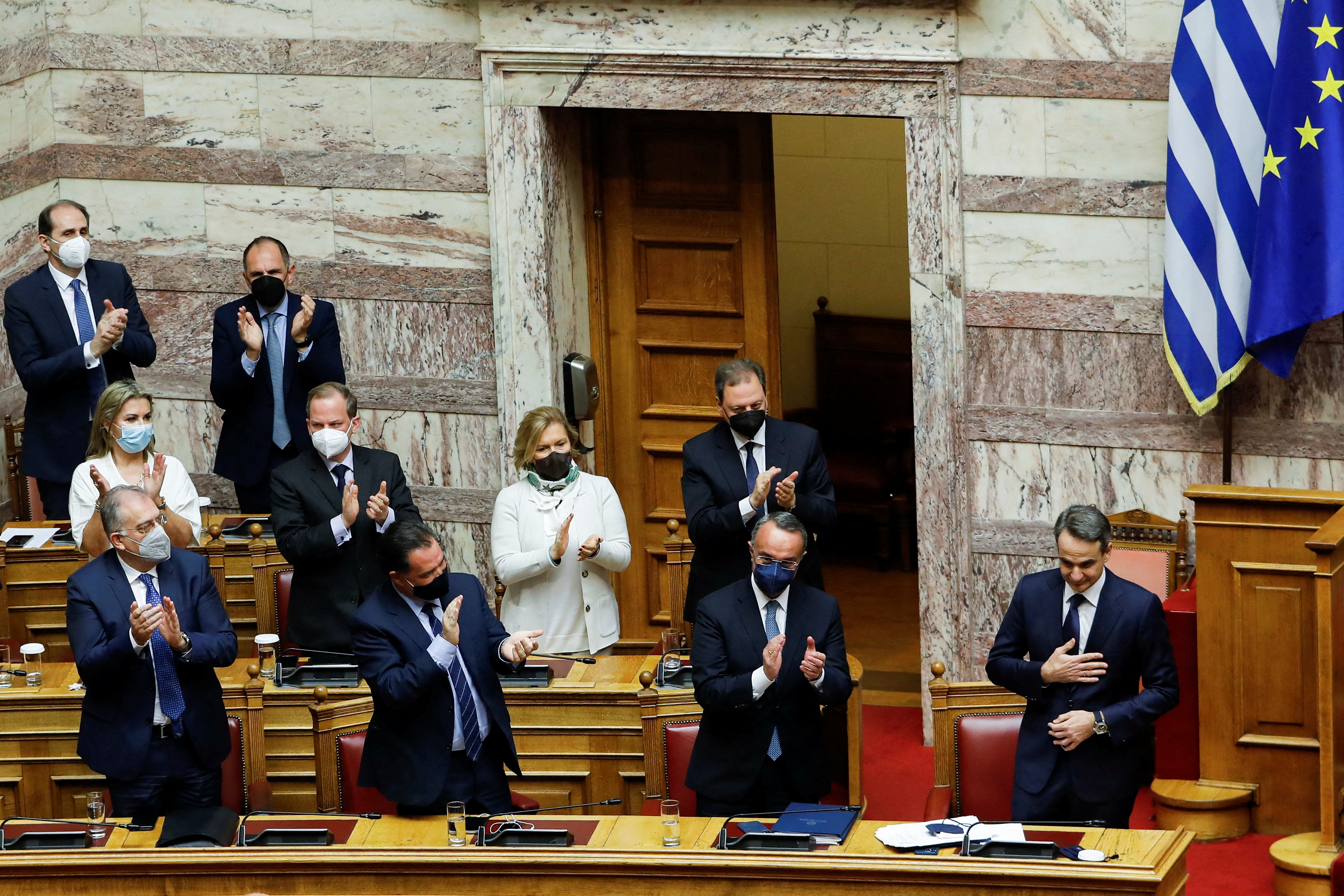 Ο Έλληνας Πρωθυπουργός Κυριάκος Μητσοτάκης δέχεται χειροκροτήματα από τους υπουργούς της κυβέρνησής του μετά από ομιλία κατά τη διάρκεια κοινοβουλευτικής συνόδου πριν από την ψήφο εμπιστοσύνης στην Αθήνα, Ελλάδα, 30 Ιανουαρίου 2022. REUTERS/Κώστας Μπαλτάς