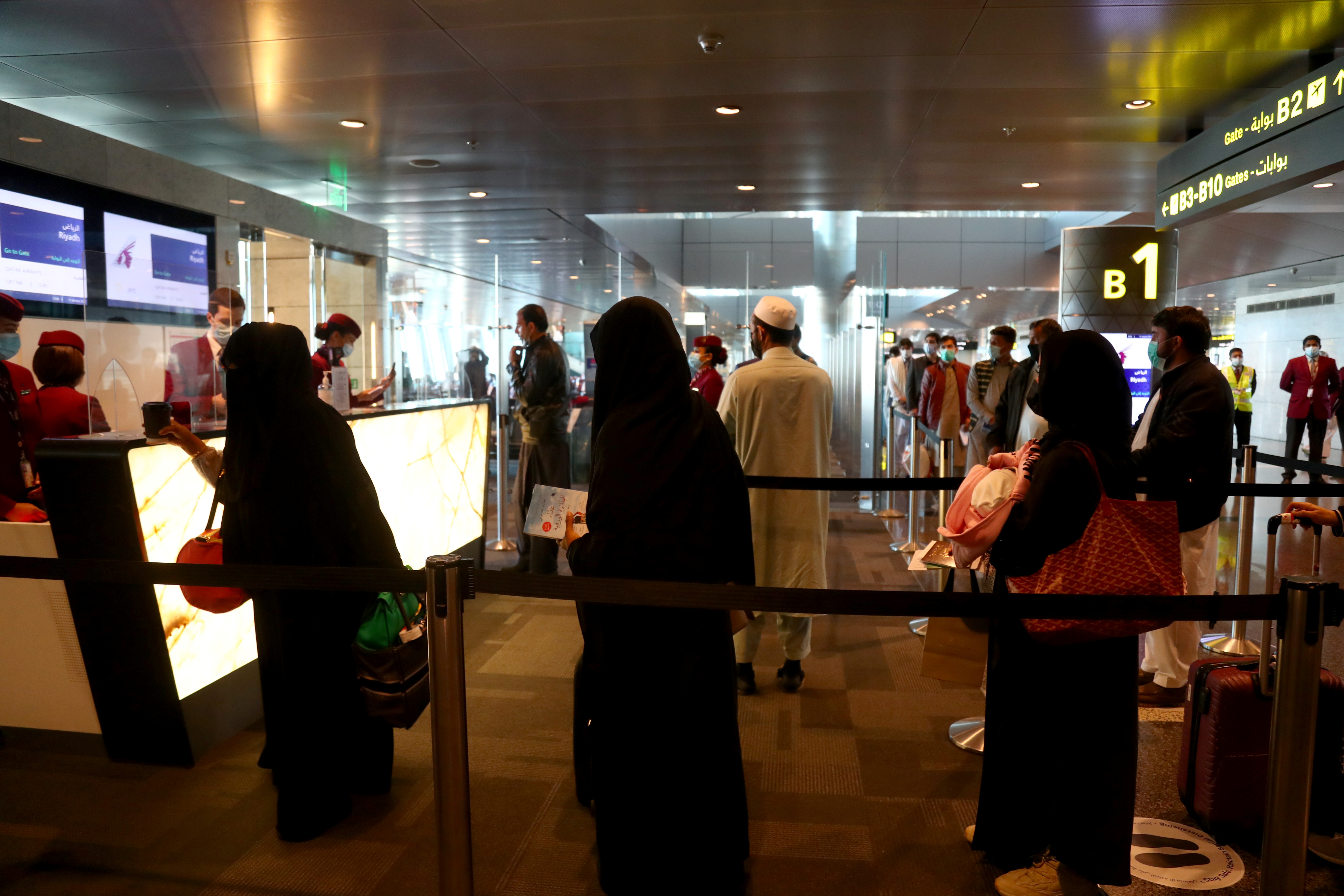 Passengers queue to check-in at Hamad International Airport, as the country resumes international flights to Saudi Arabia, in Doha