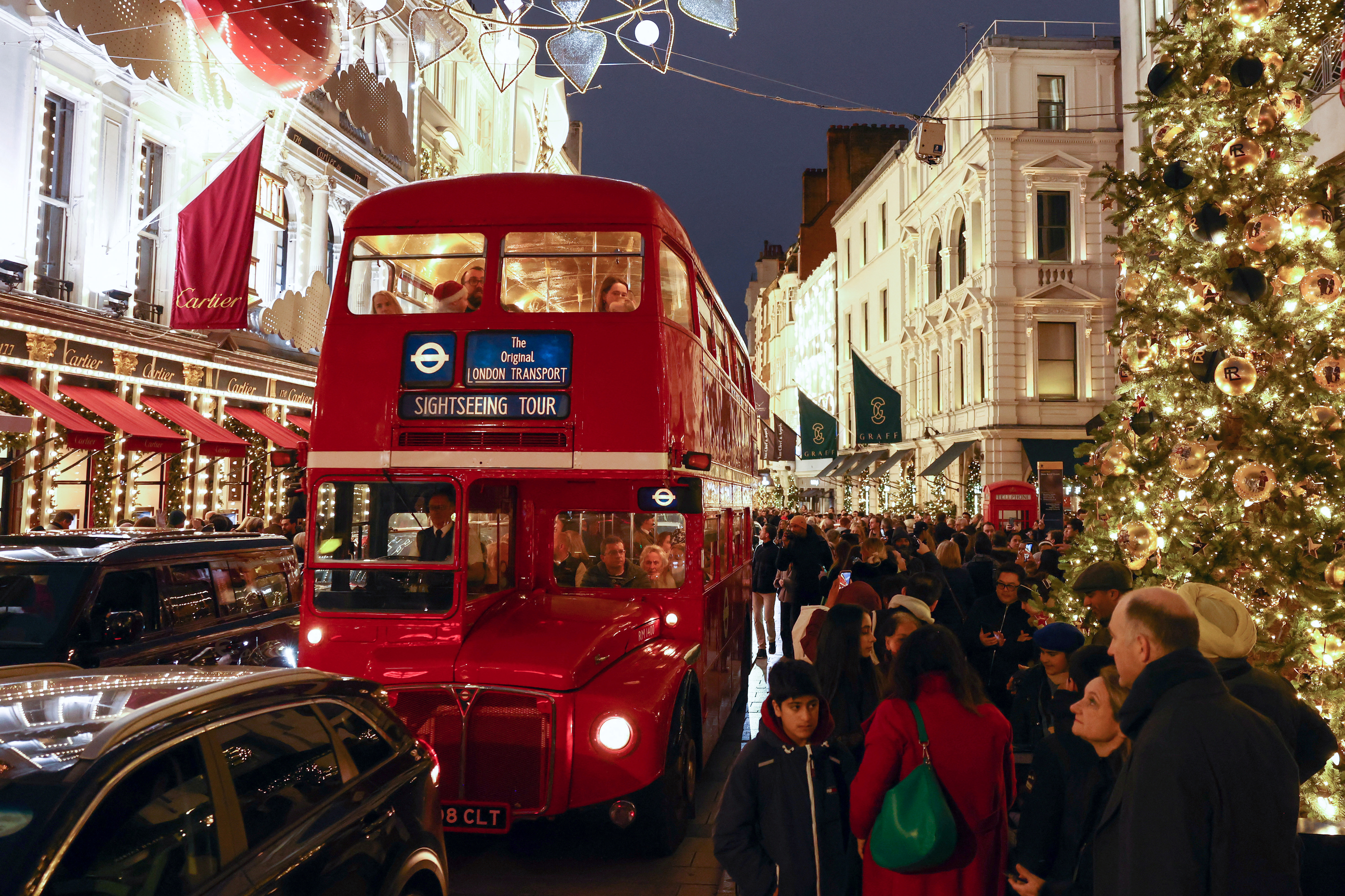 A Routemaster bus makes its way past shops with Christmas decorations on Bond Street