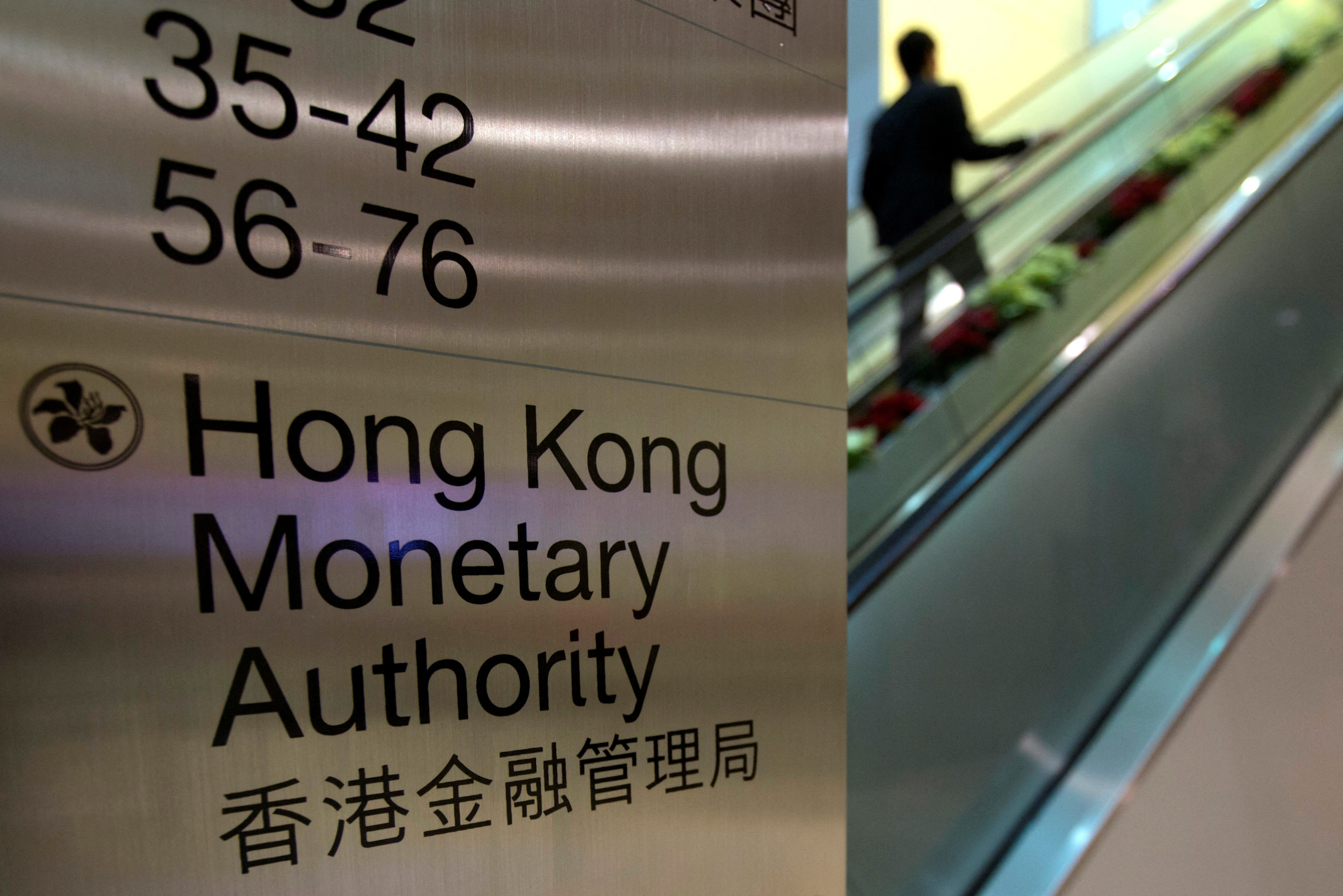 A security guard walks past a directory board of Hong Kong Monetary Authority (HKMA) in Hong Kong