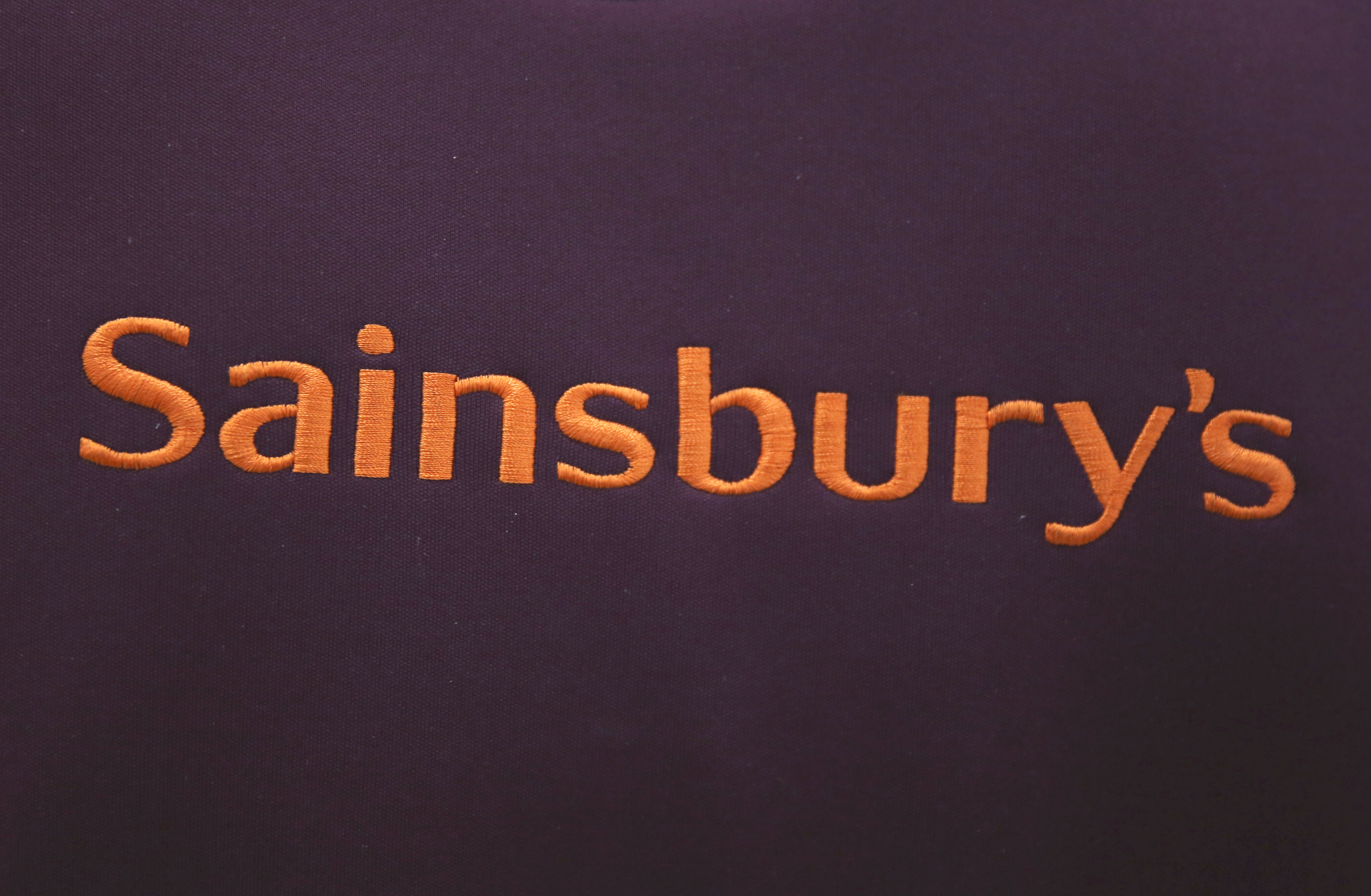 A worker's uniform displays company branding at a Sainsbury's store in London