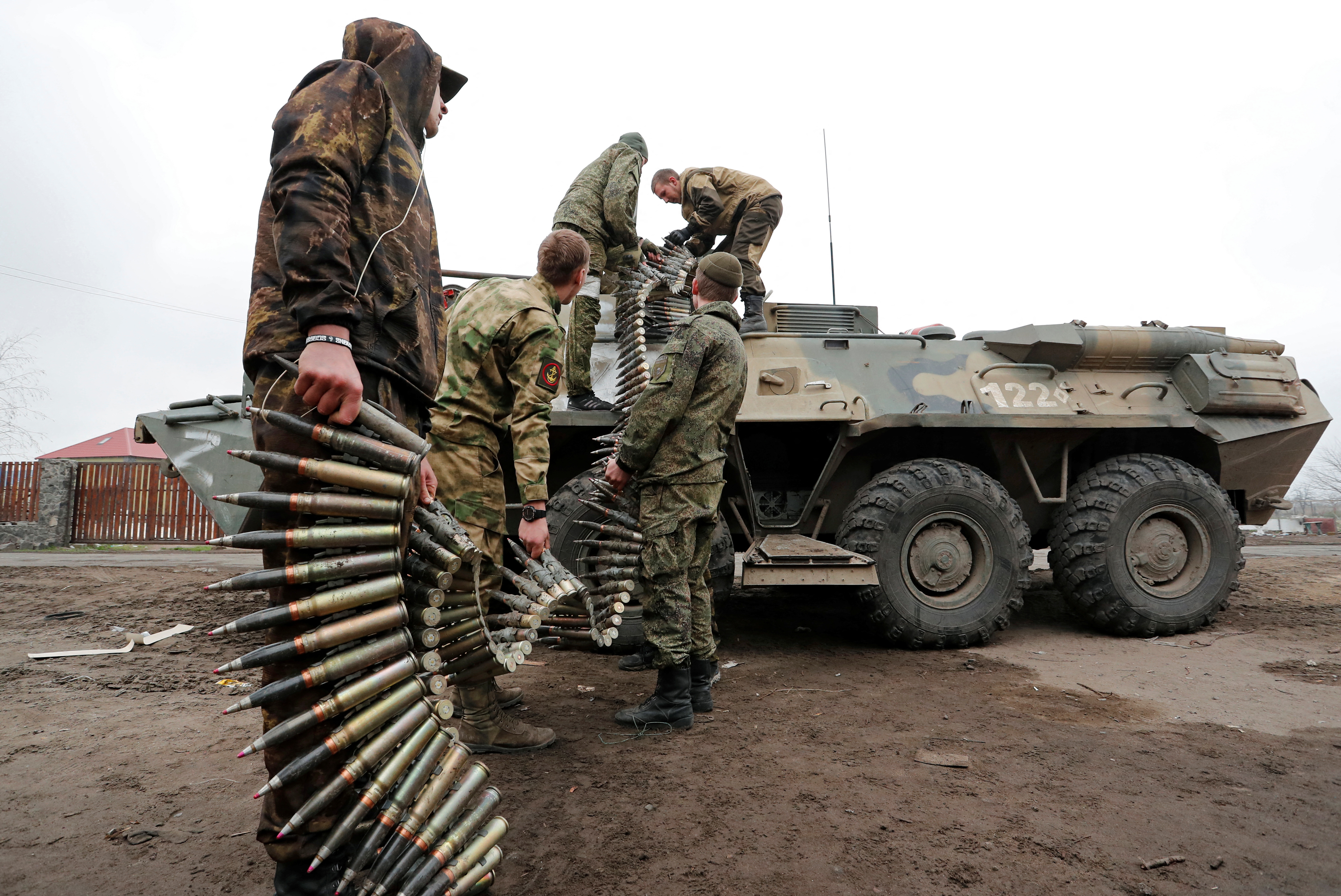 Service members of pro-Russian troops load ammunition into an armoured personnel carrier in Mariupol