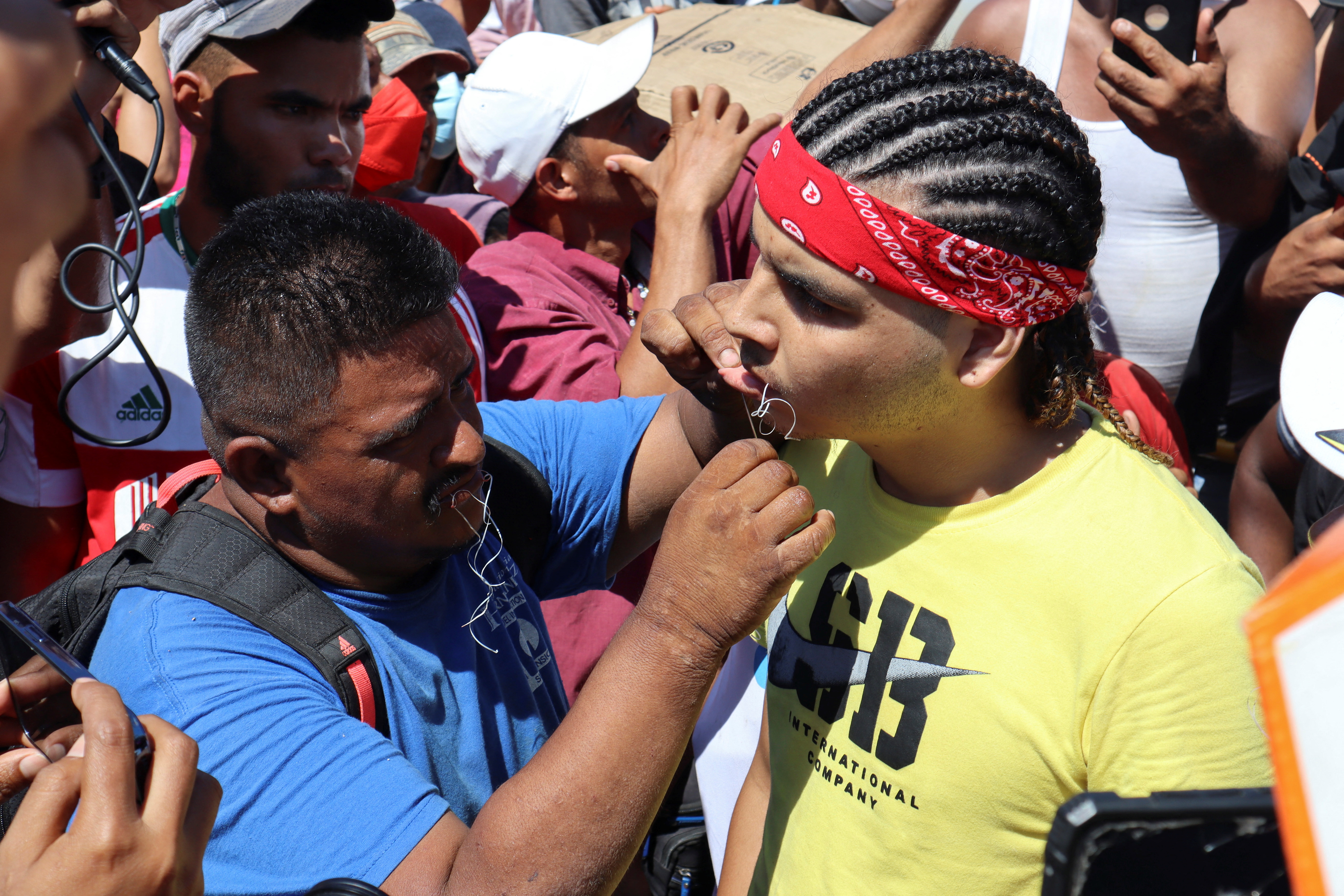 A migrant begins a hunger strike with his mouth sewed shut during a protest to demand free transit through the country outside the office of the National Migration Institute (INM) in Tapachula