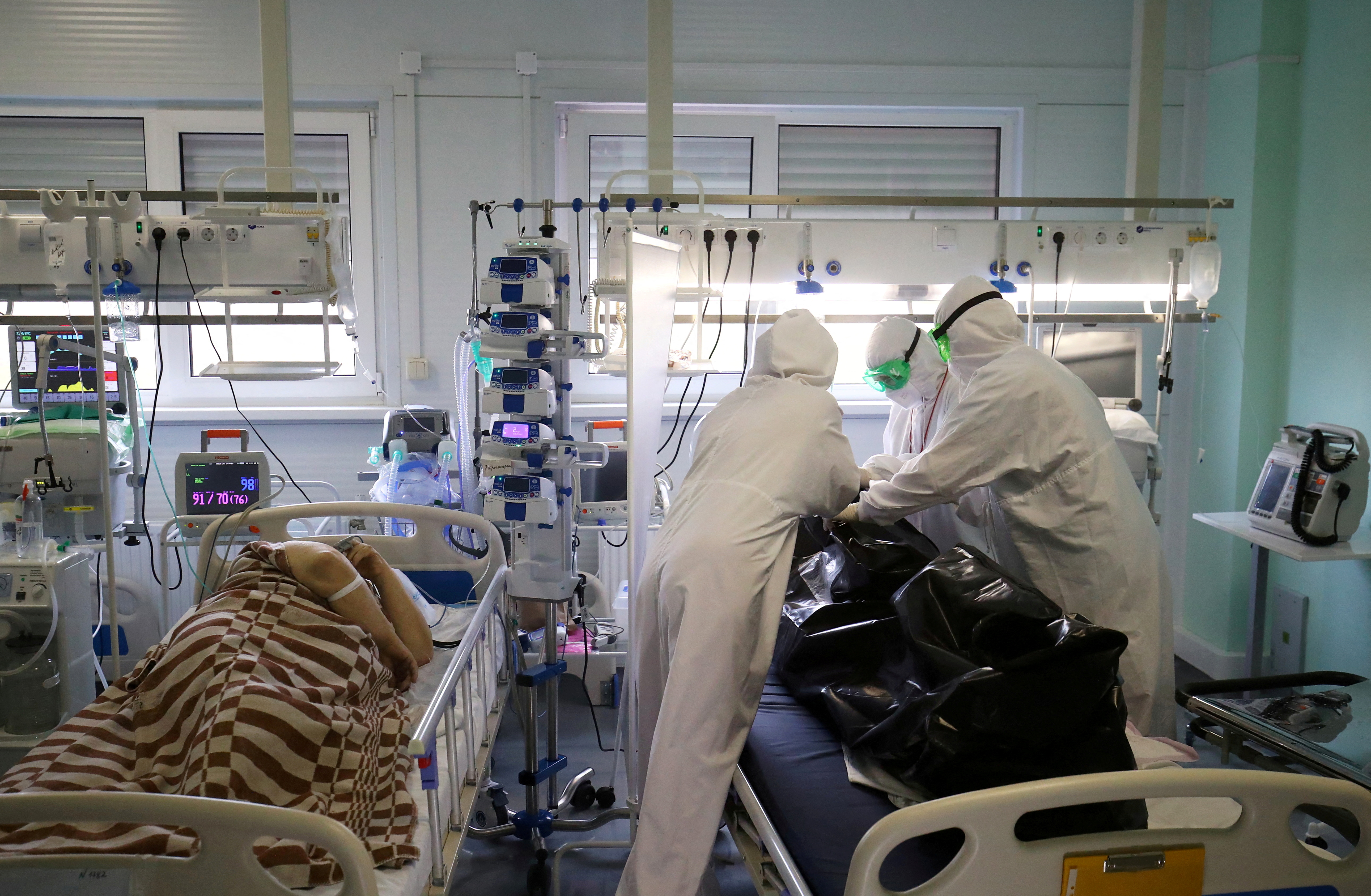 Medical specialists place the body of a person who died at the ICU unit for coronavirus disease (COVID-19) patients in a bag at a local hospital in the town of Kalach-on-Don in Volgograd Region, Russia November 14, 2021. REUTERS/Kirill Braga