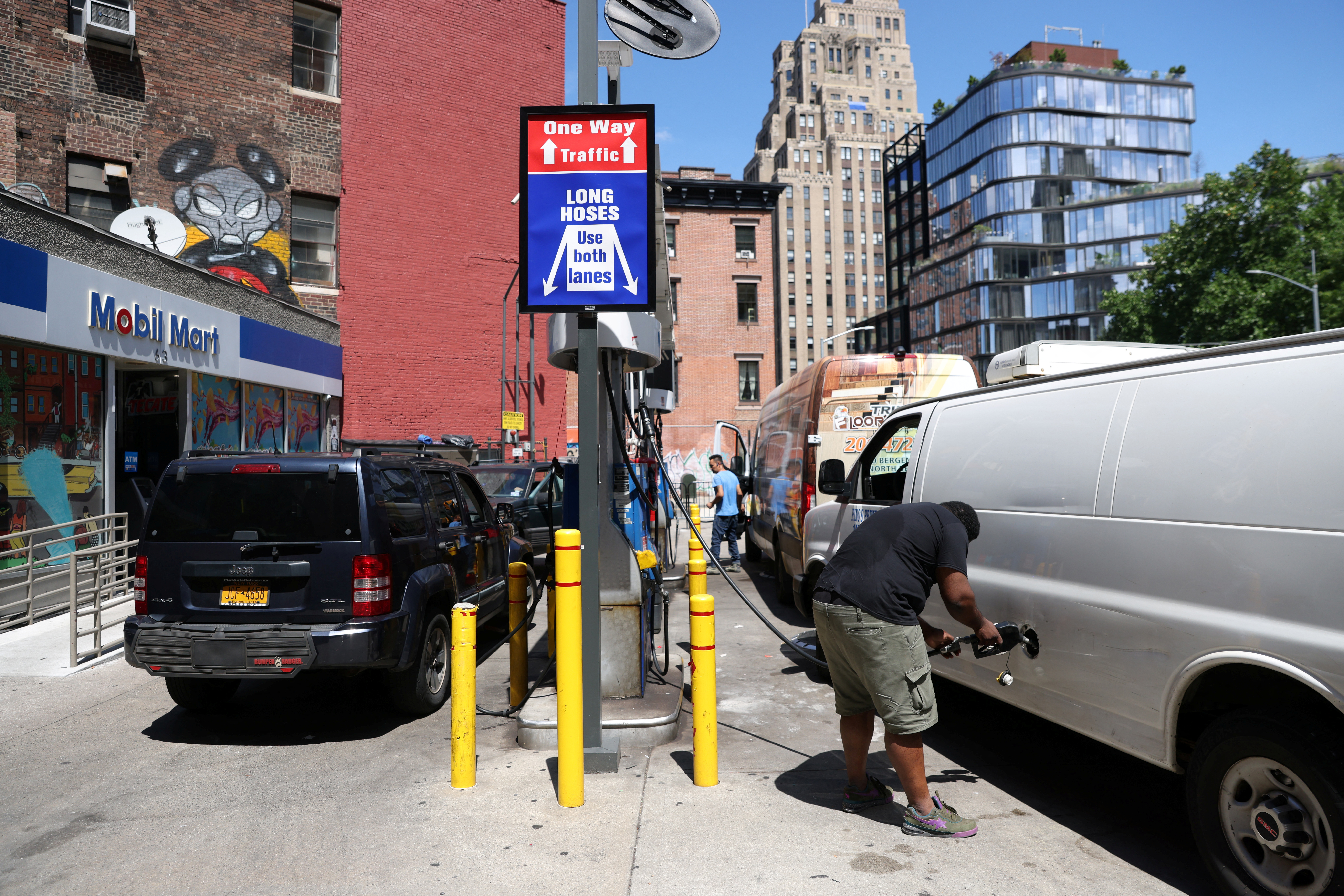 People put gas in their vehicles at a gas station in Manhattan, New York City