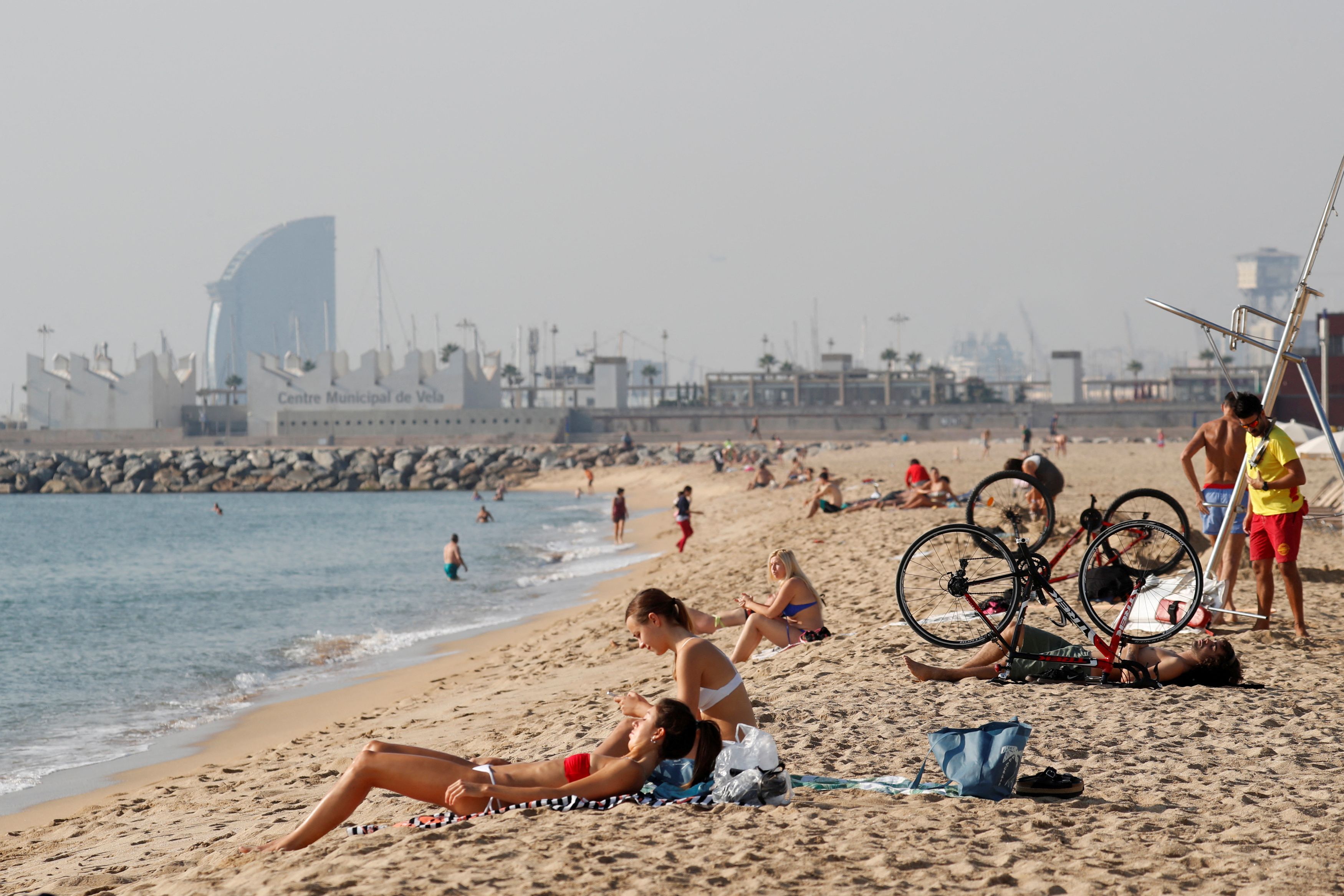People sunbathe on Barceloneta beach in Barcelona