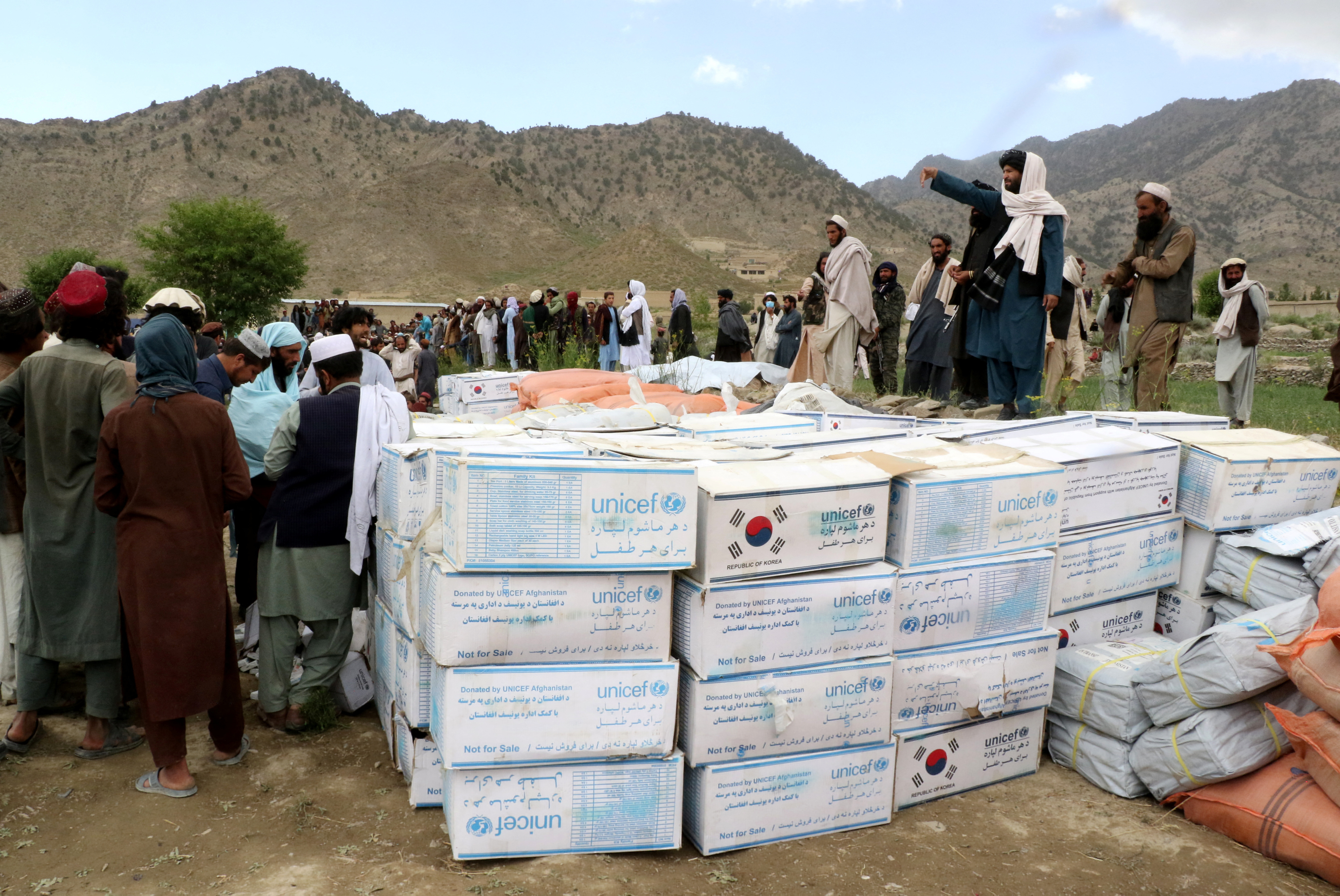 Afghan men gather to collect relief goods after a recent earthquake in Gayan