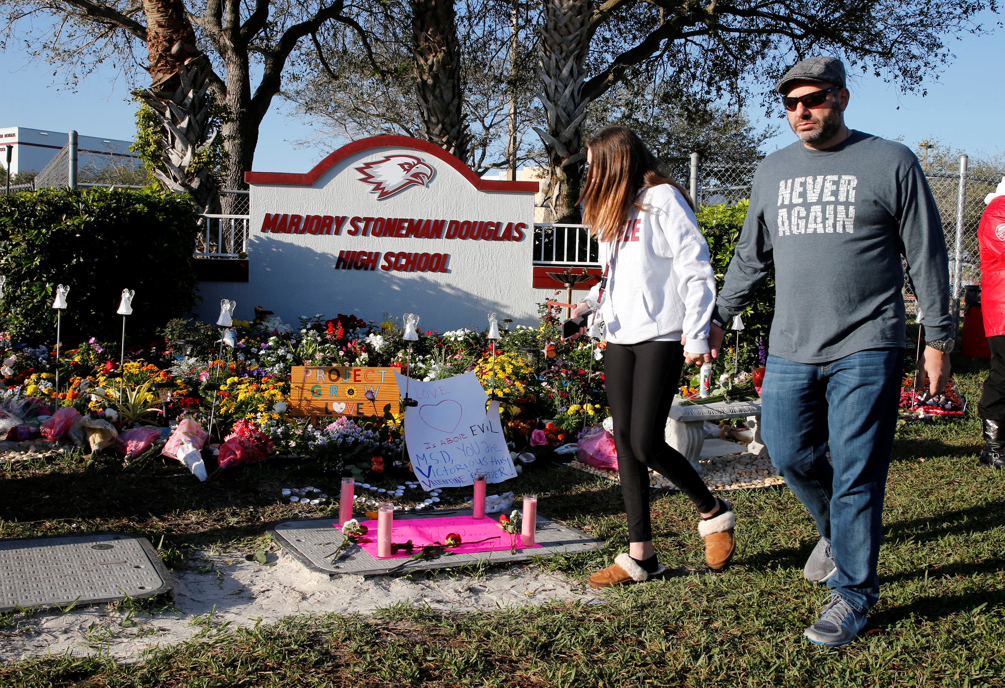 Visitors who asked to not be identified walk past a memorial on the one year anniversary of the shooting which claimed 17 lives at Marjory Stoneman Douglas High School in Parkland