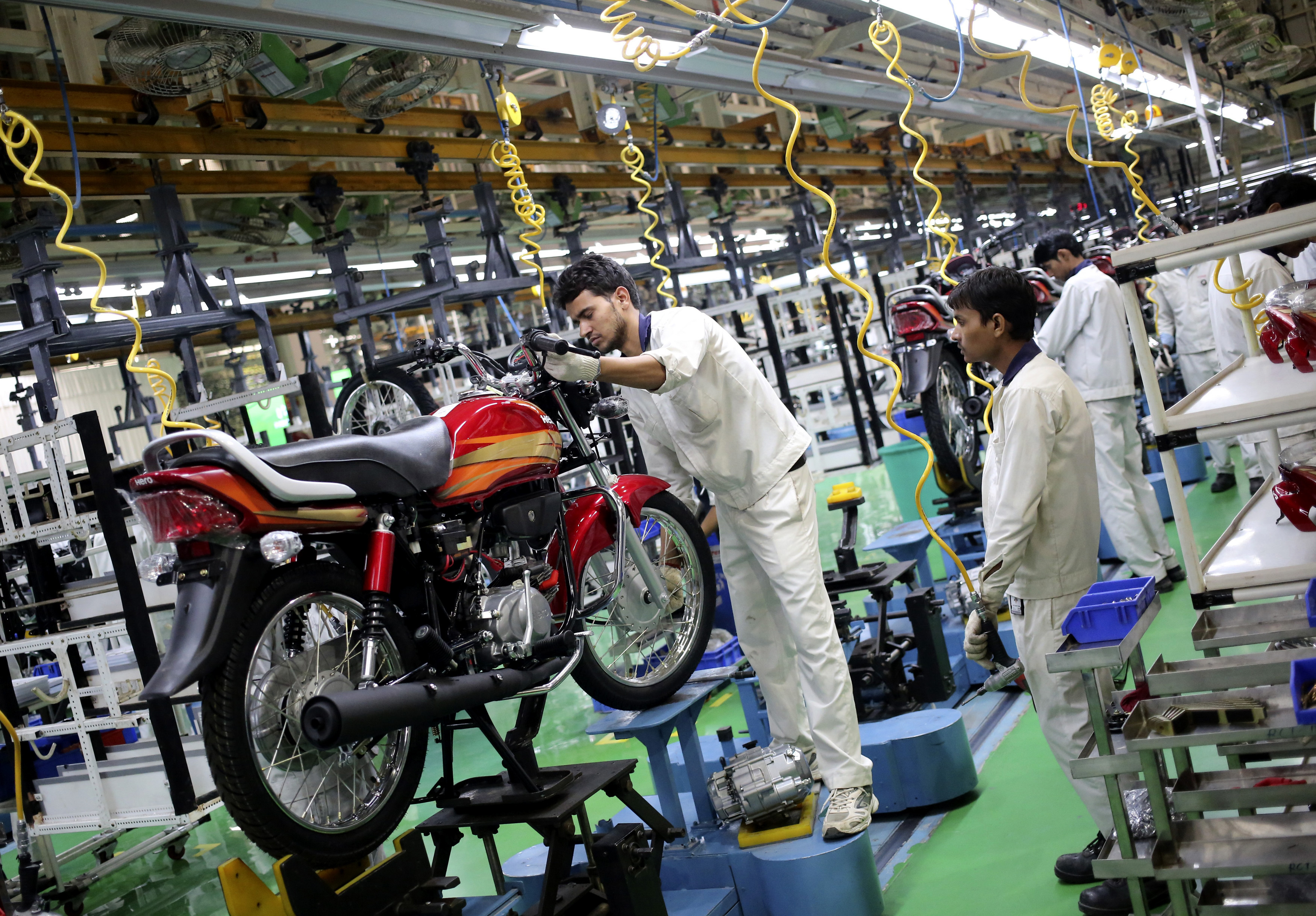 Employees work on an assembly line of Hero Motocorp during a media tour to the newly opened plant in Neemrana