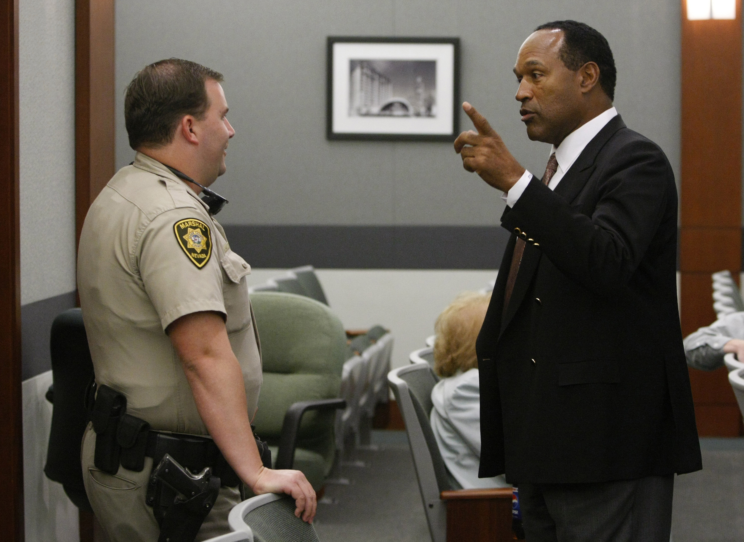 O.J. Simpson talks with deputy marshal Doug Hale after the second day of jury selection for Simpson's trial at the Clark County Regional Justice Center in Las Vegas