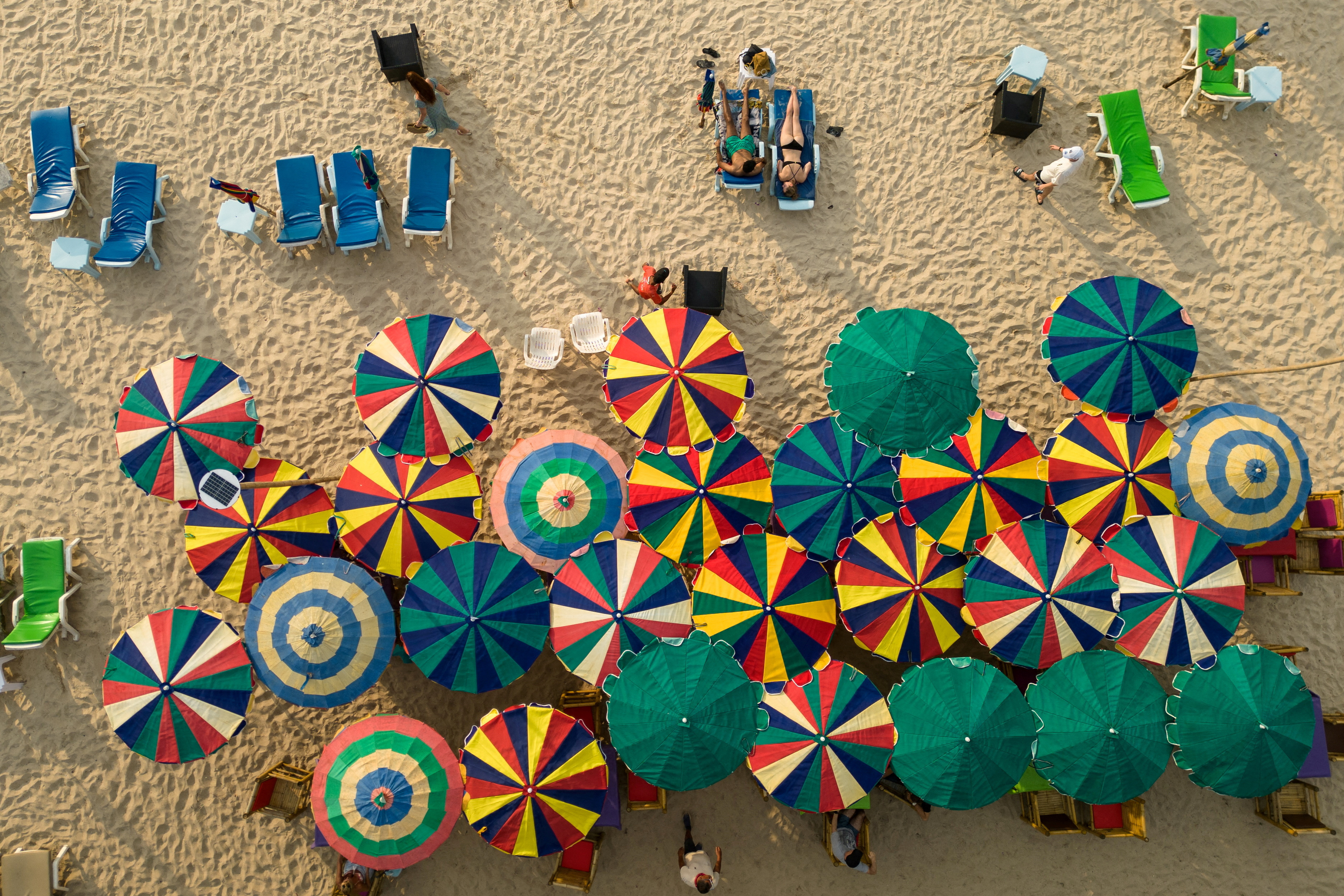 Colorful umbrellas are seen in a restaurant as tourists enjoy a beach in the island of Phuket in Thailand