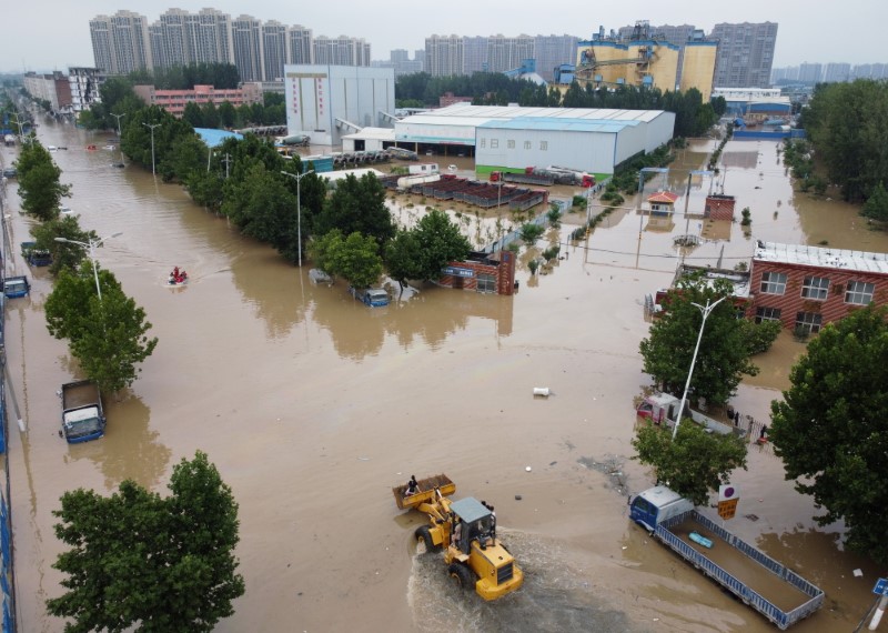 An aerial view shows rescue workers evacuating residents on a flooded road following heavy rainfall in Zhengzhou, Henan province, China July 22, 2021. Picture taken with a drone.  REUTERS/Aly Song/File Photo