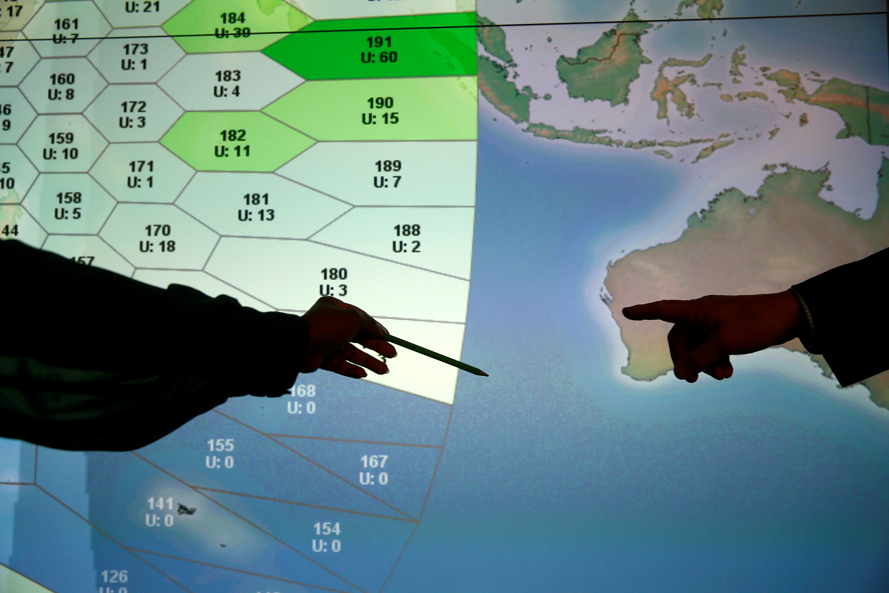 Member of staff at satellite communications company Inmarsat point to a section of the screen showing the southern Indian Ocean to the west of Australia, at their headquarters in London, Britain, March 25, 2014. REUTERS/Andrew Winning/File Photo