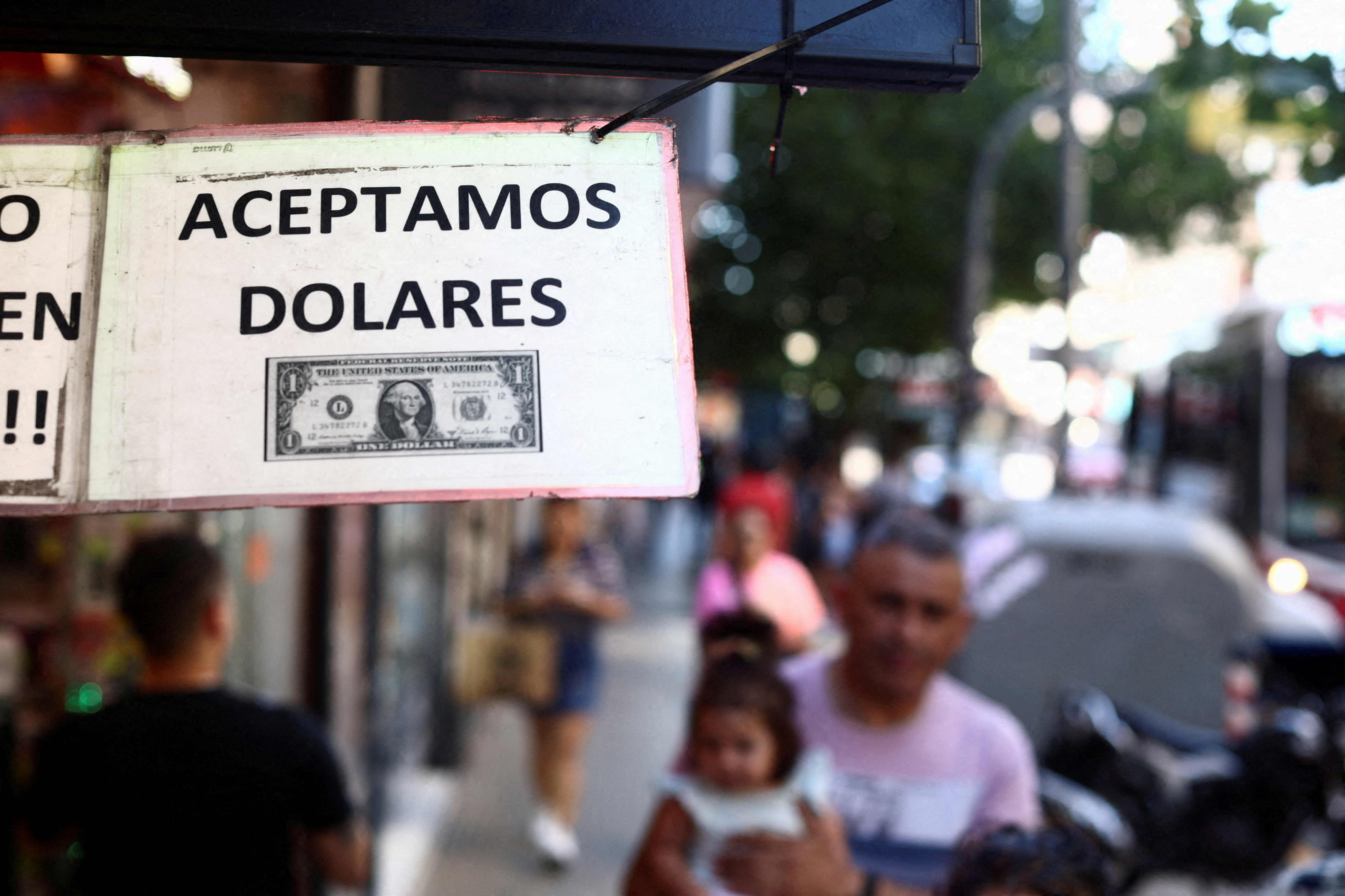 A sign outside a store reads in Spanish "We accept Dollars" in Buenos Aires