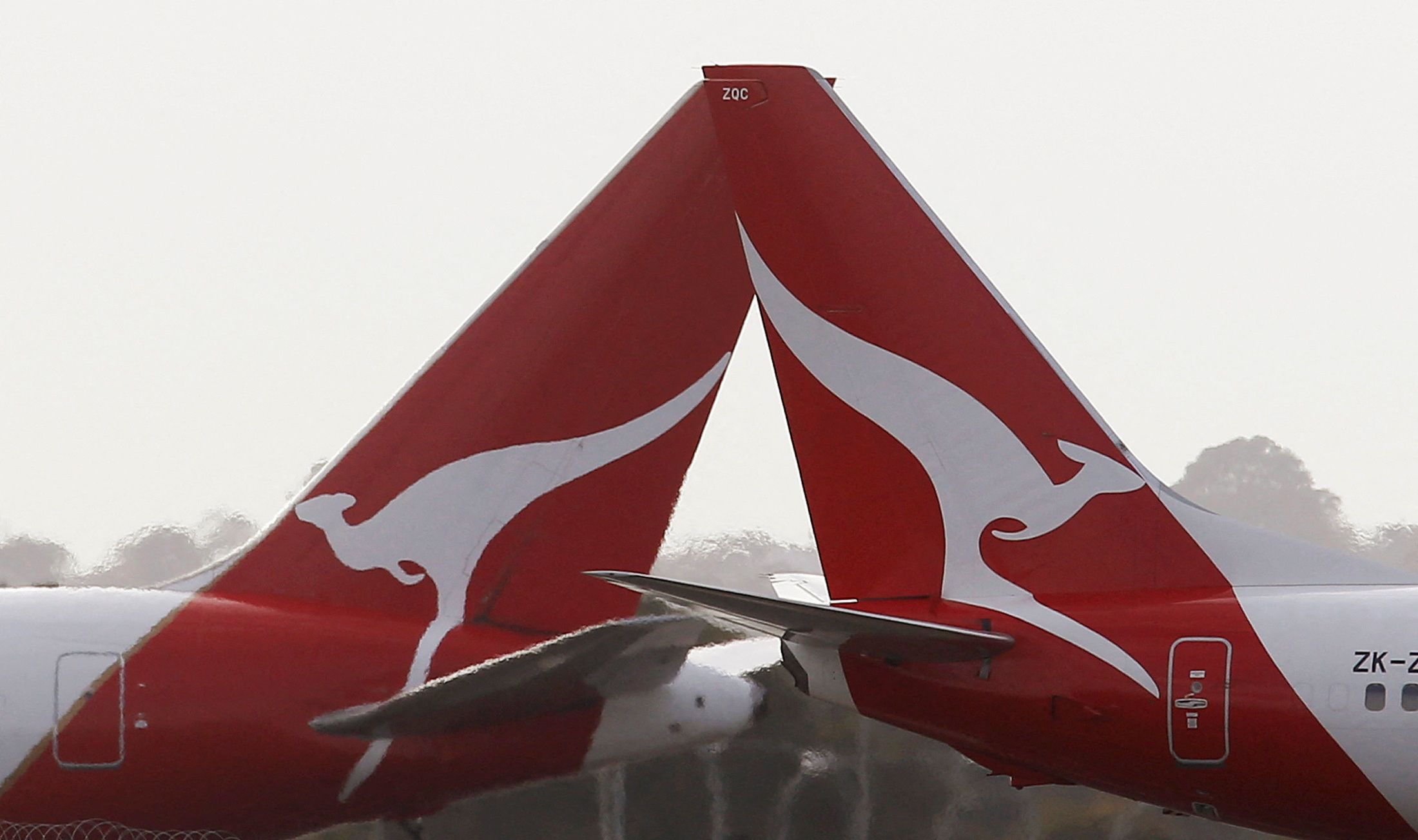 Two Qantas passenger jets cross each other at Kingsford Smith International airport in Sydney