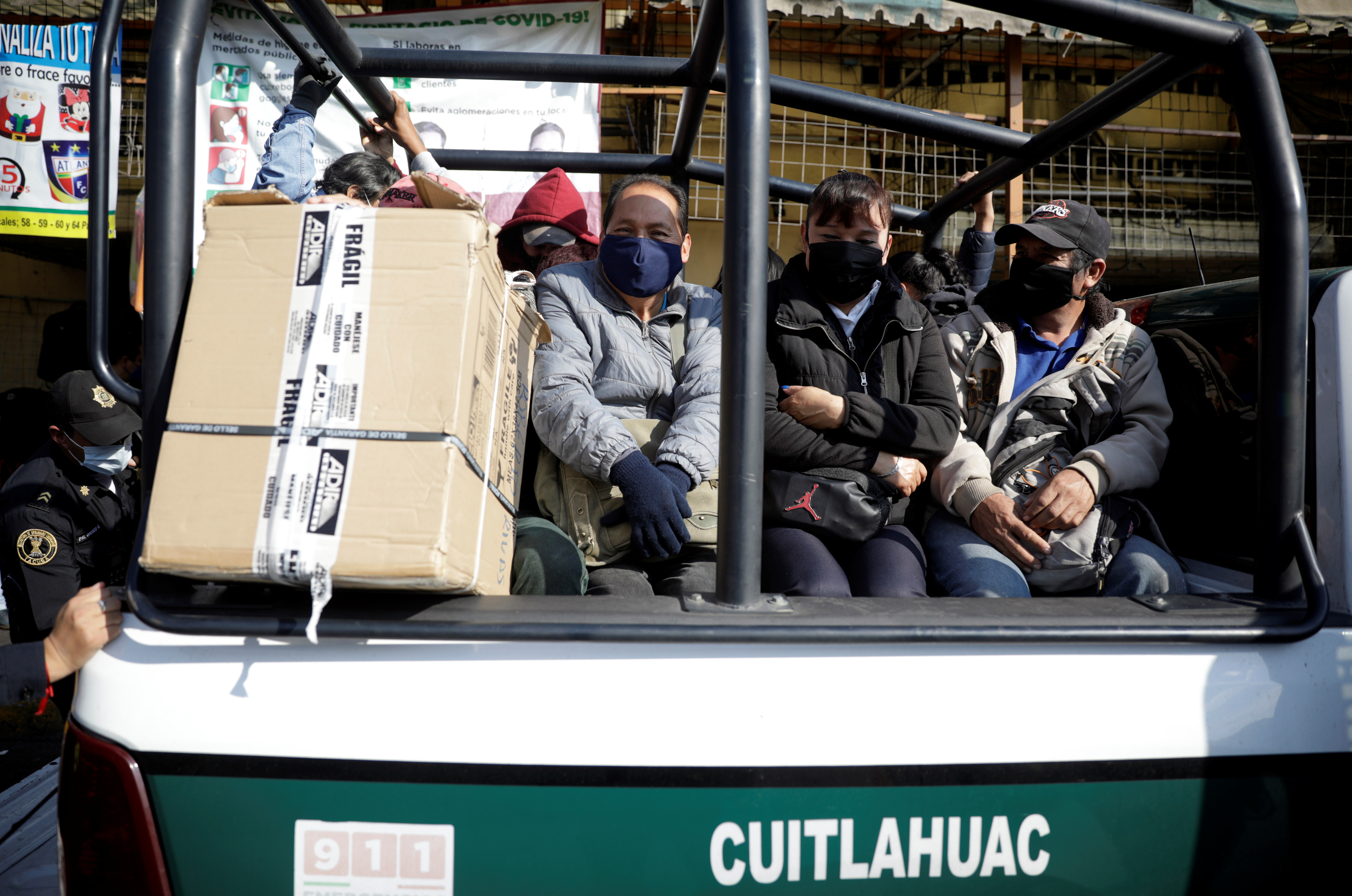 People sit in a police vehicle after six lines of the capital's extensive underground metro lines were disconnected due to a fire struck at the subway headquarters in central Mexico City