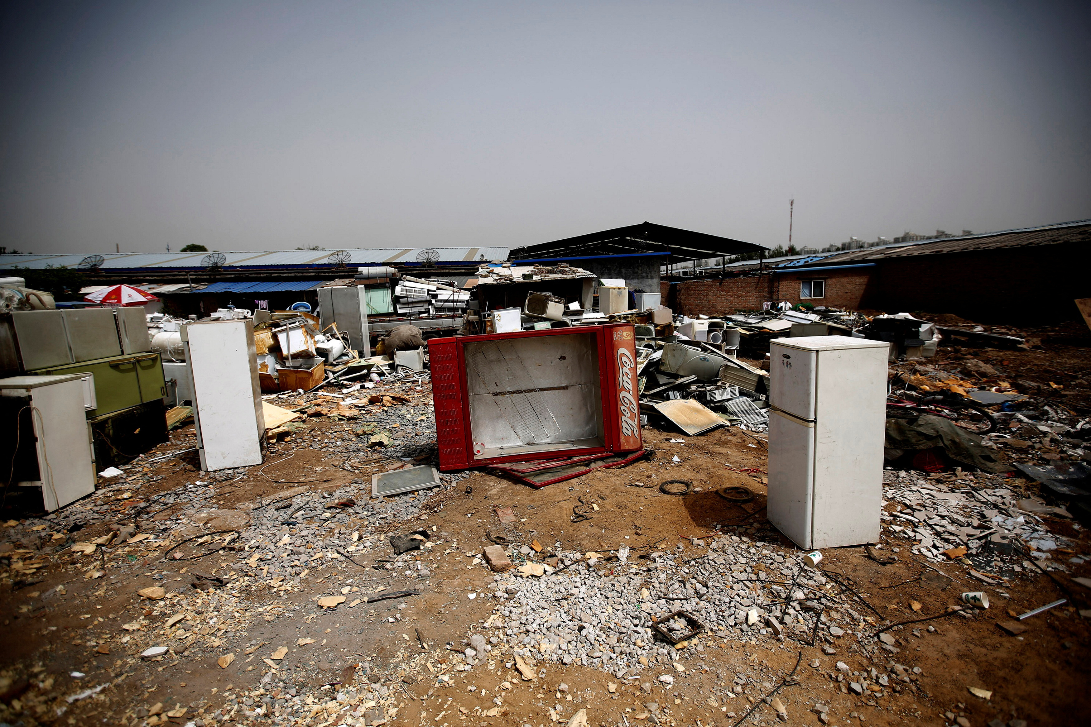 Broken fridges are seen in the yard of a recycling workers' tenement house in Dongxiaokou village in Beijing