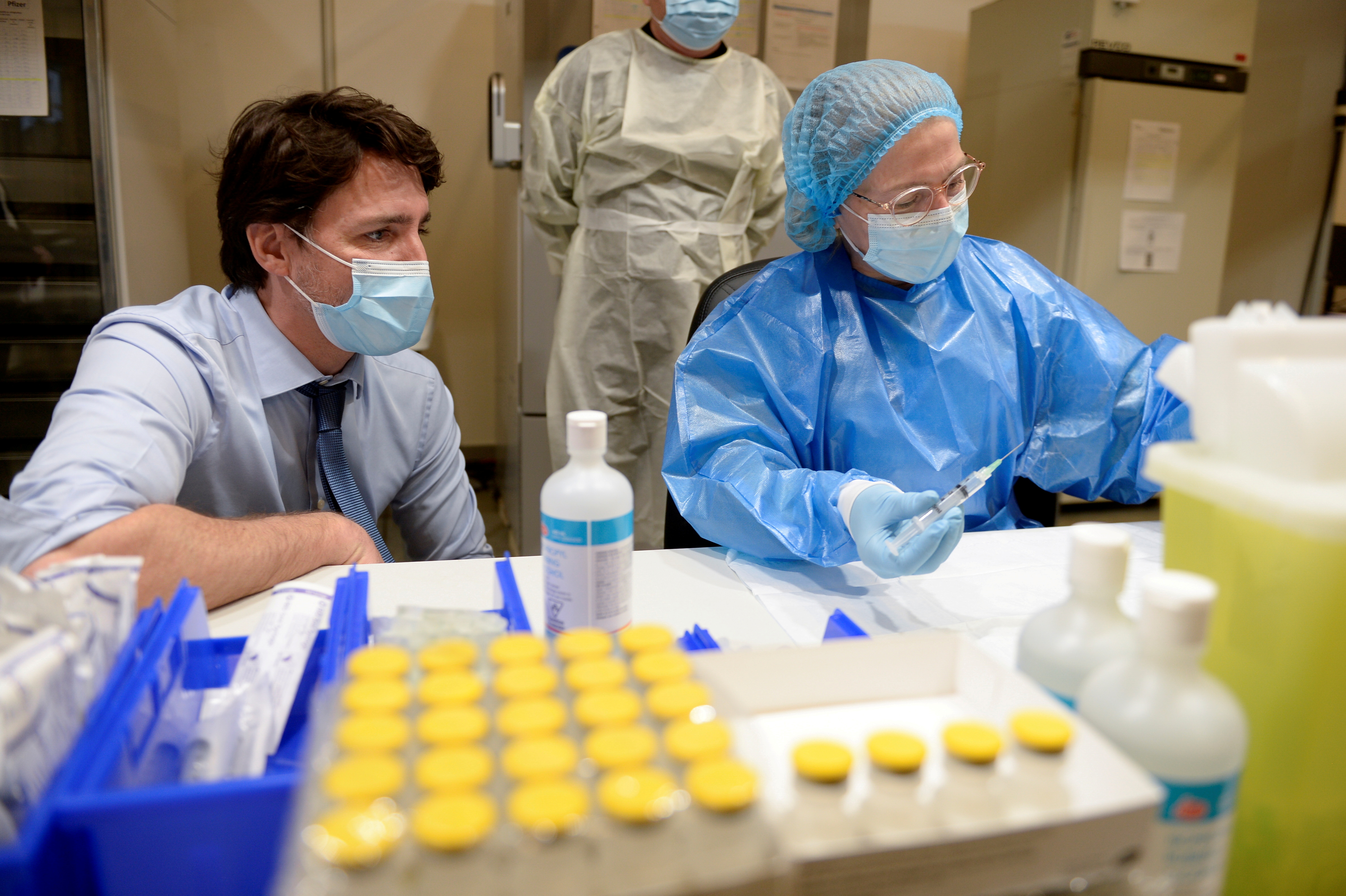 Canada's Prime Minister Justin Trudeau watches the Pfizer-BioNTech vaccine being extracted while he visits a vaccination clinic at the Palais des Congres, as efforts continue to help slow the spread of the coronavirus disease (COVID-19), in Montreal, Quebec, Canada March 15, 2021. REUTERS/Andrej Ivanov