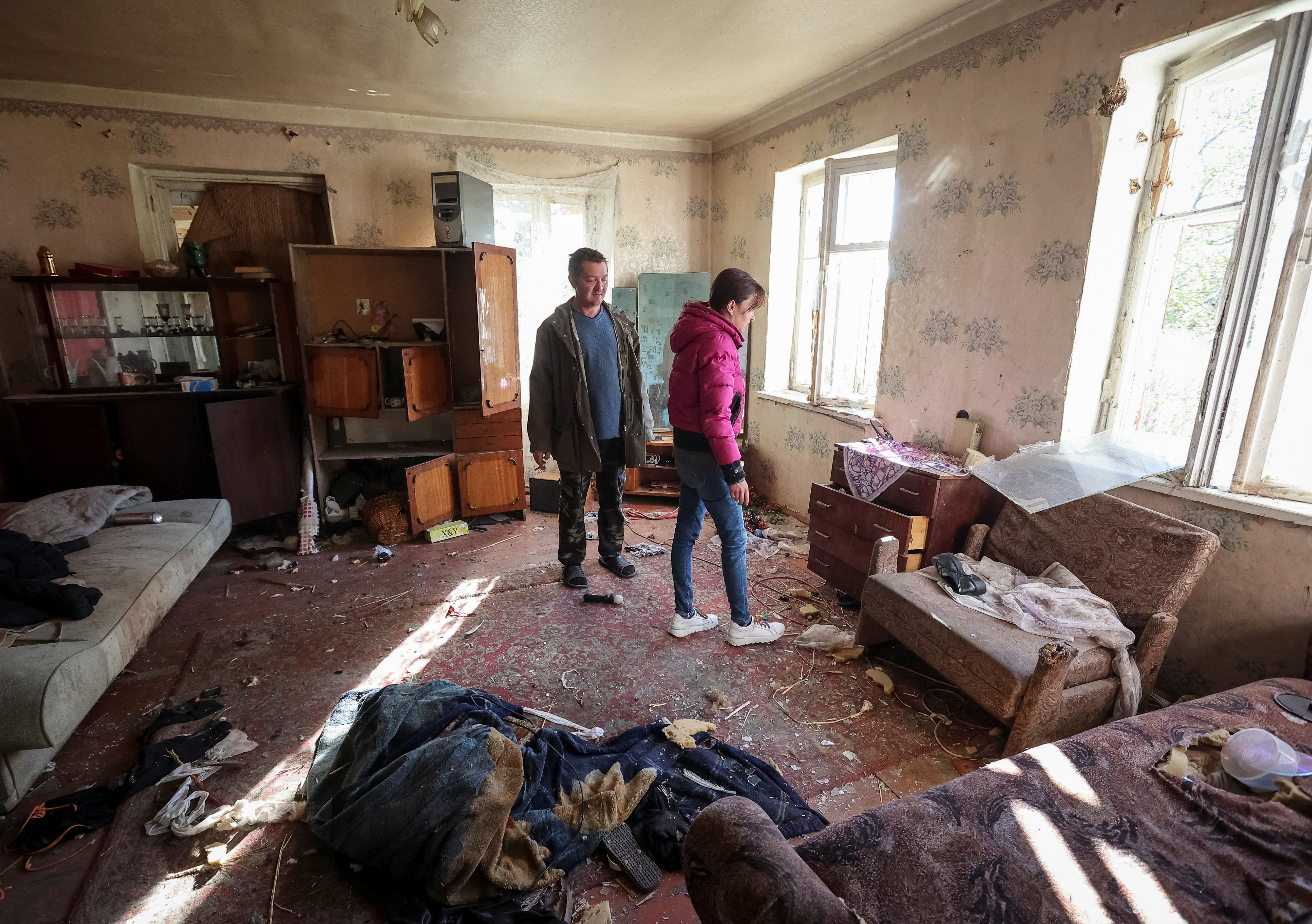 Olha Shevchenko, 39, and her husband Evgen look for their things in their house, damaged by the Russian military strike in Kharkiv