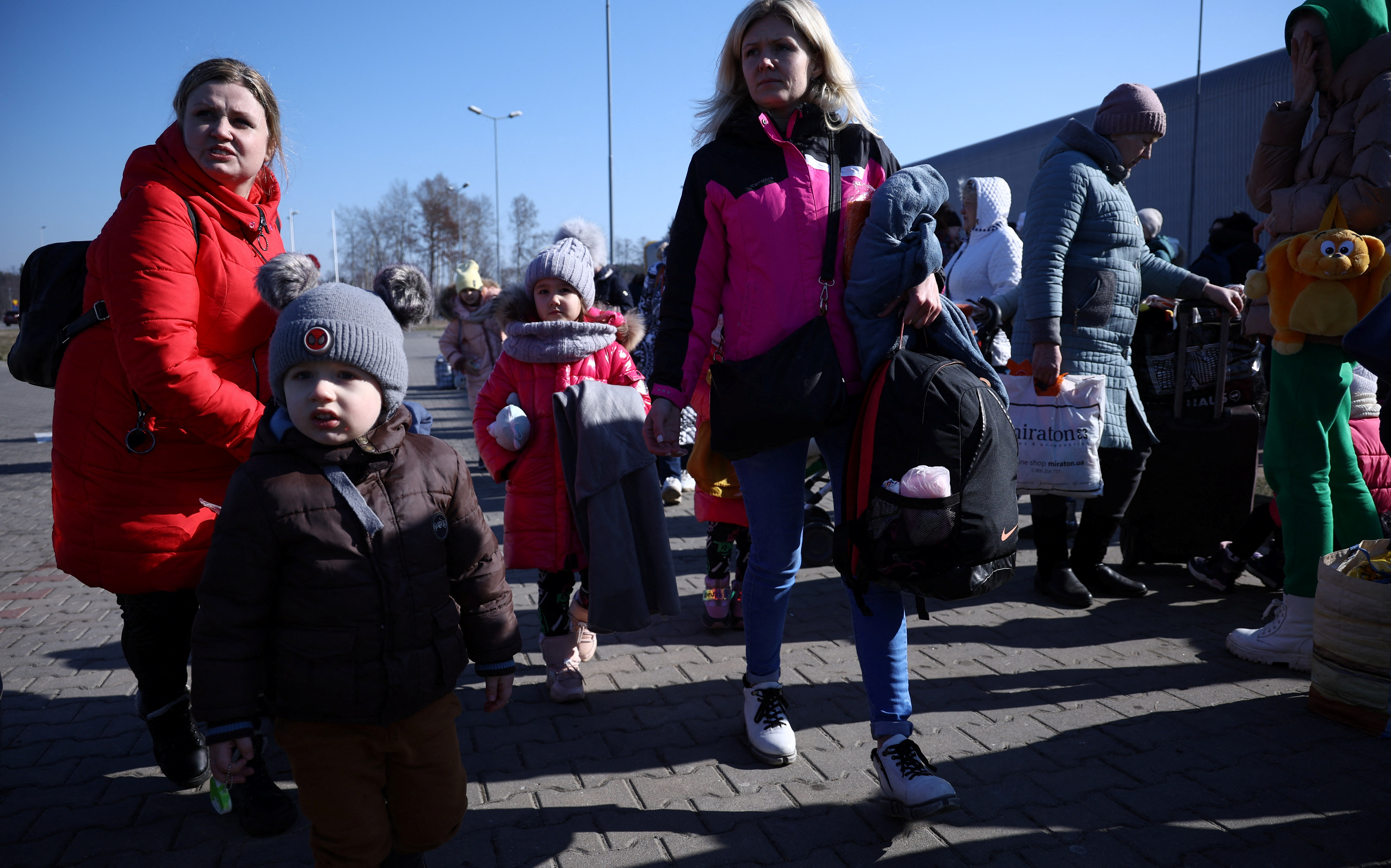 People walk in front of the reception center for refugees, in Nadarzyn