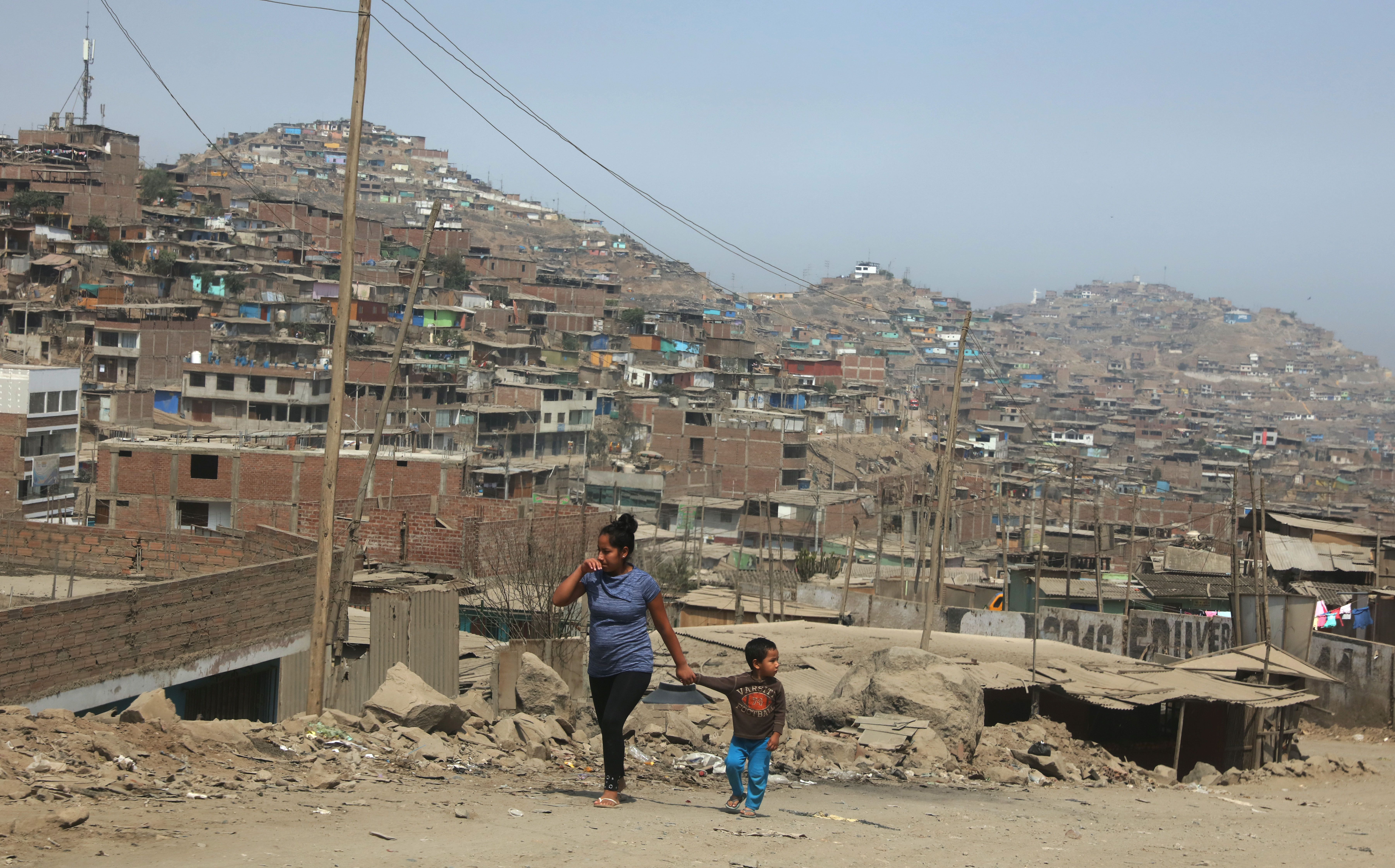 A woman and child walk on the hills  of Villa Maria del Triunfo, a shanty town on the outskirts of Lima