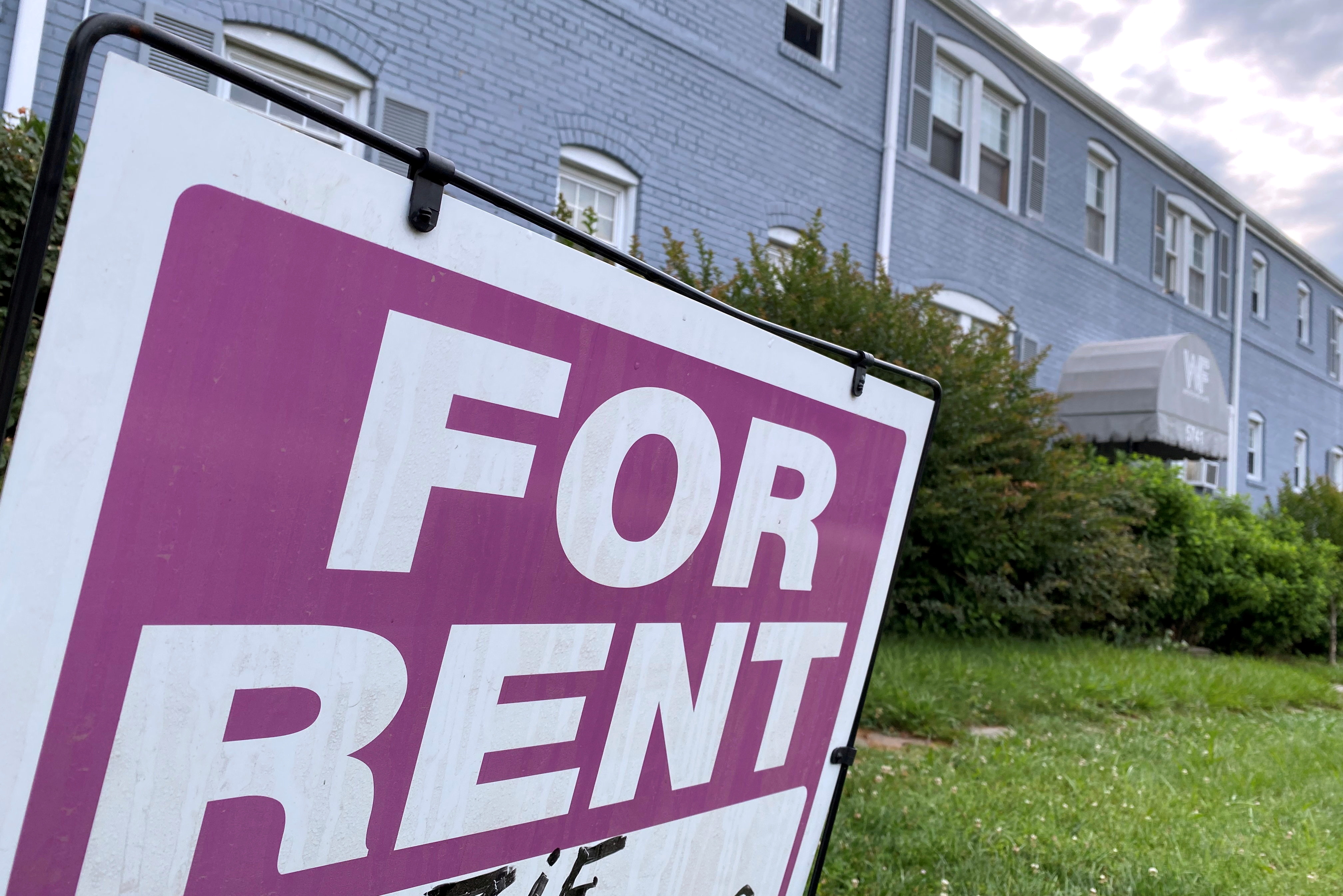 A "For Rent" sign is displayed in front of an apartment building in Arlington, Virginia, U.S.
