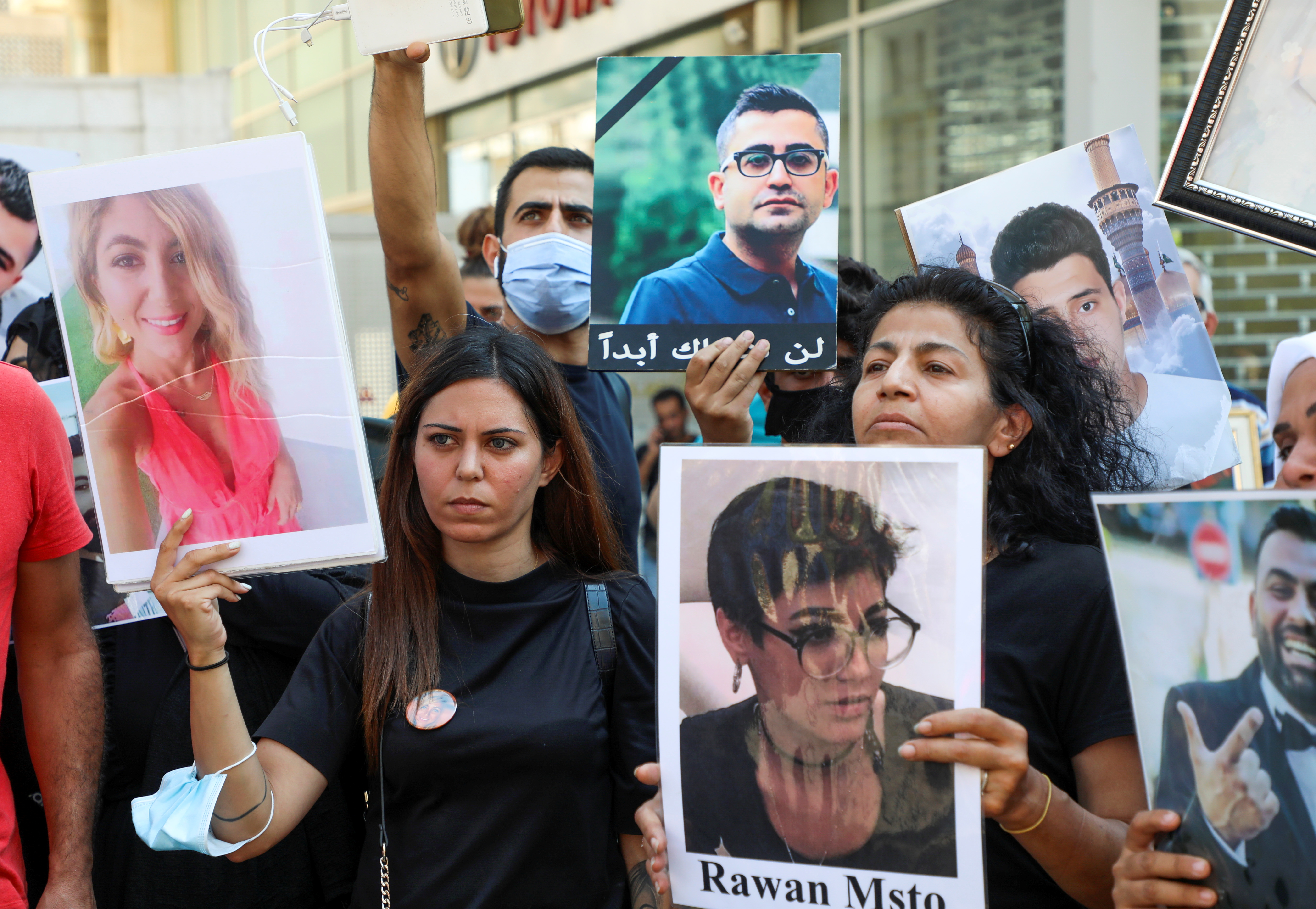 Family members of some of the victims of the August 4 explosion at Beirut port, carry their pictures during a protest demanding justice, in Beirut
