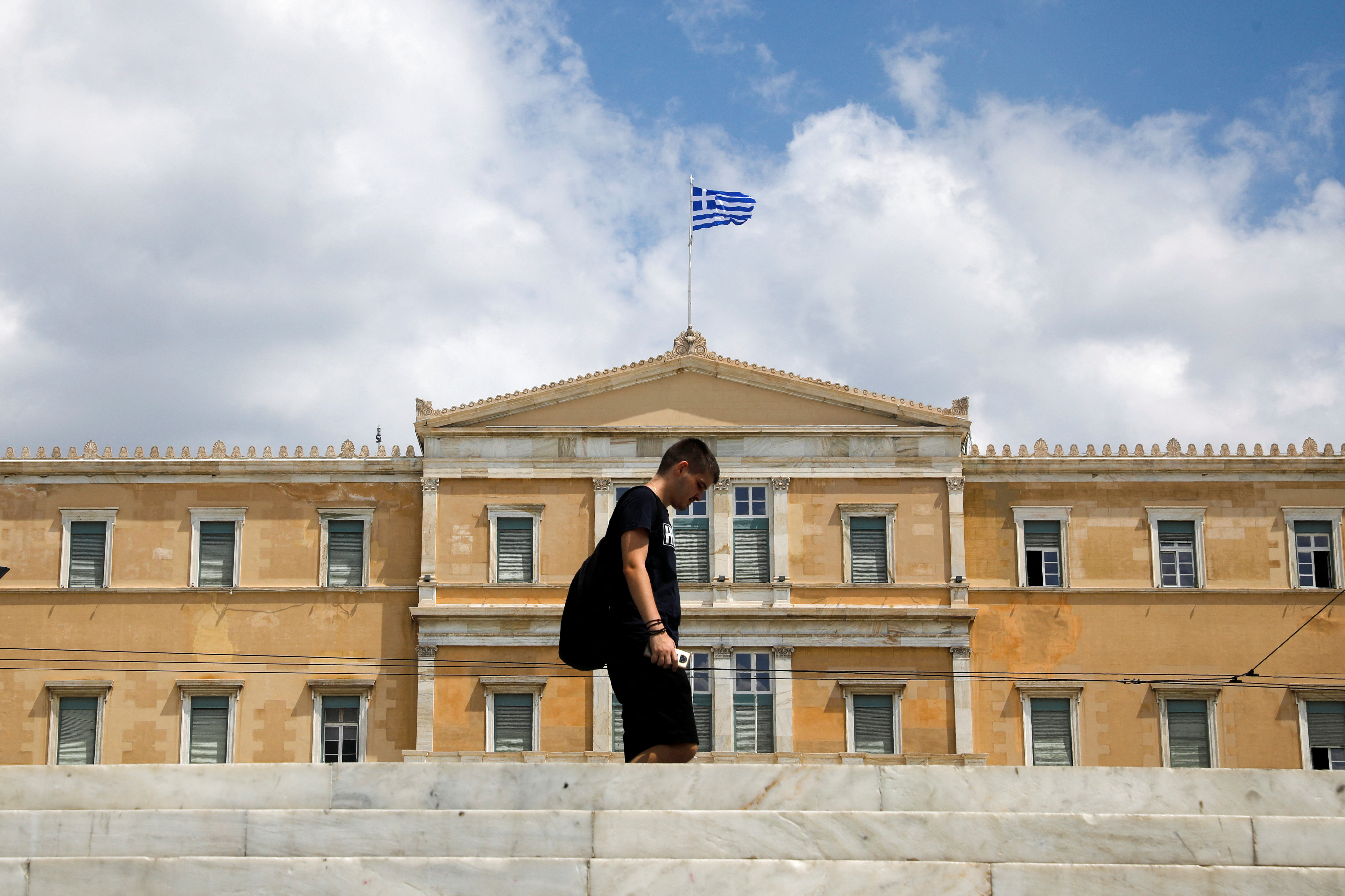 A man makes his way in front of the Greek parliament building in Athens
